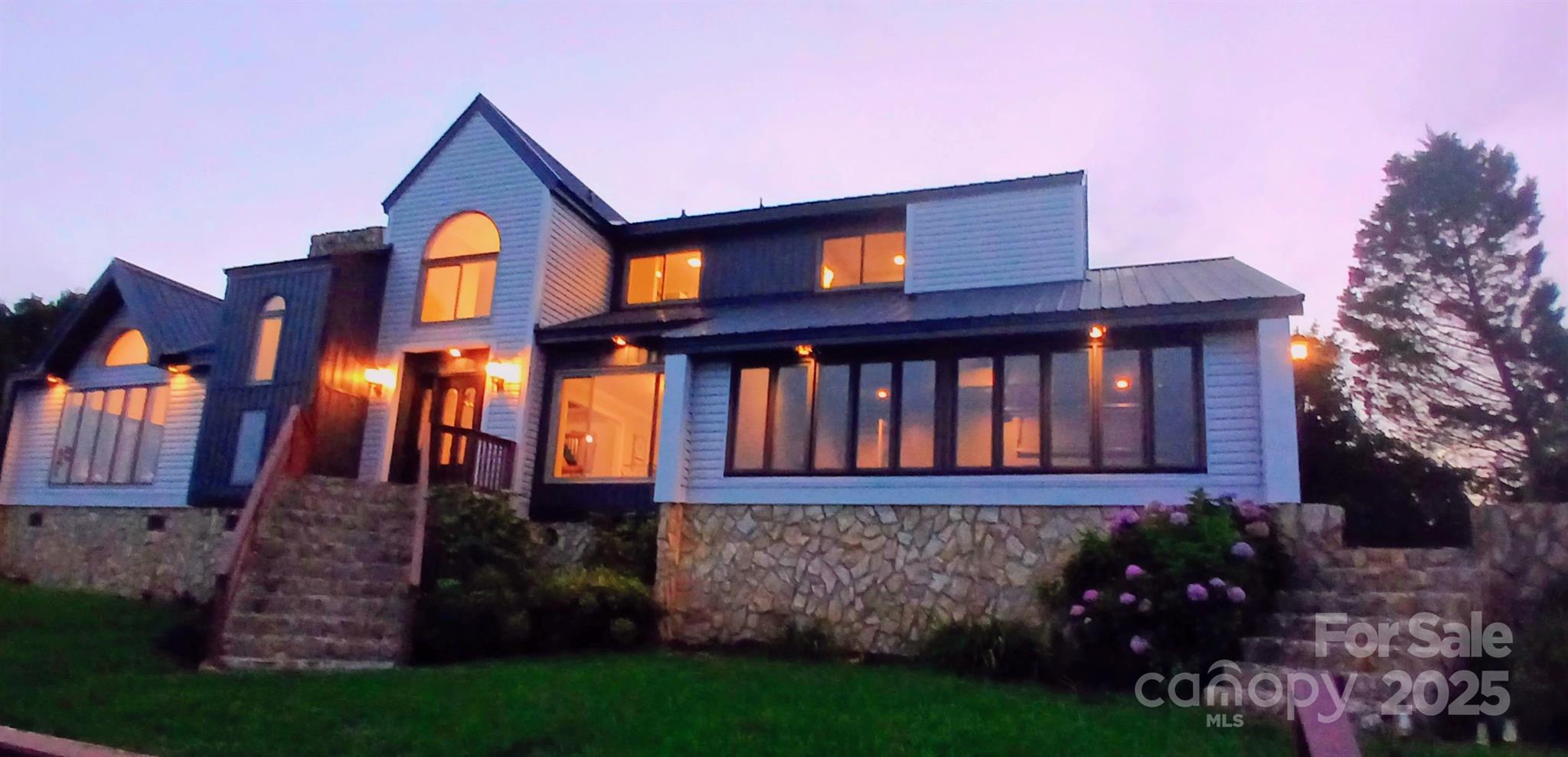 Priced below market! This spectacular home sits high atop a one acre bluff overlooking Lake Tillery, the Uwharrie Mountains, and the James Garrison Bridge. With two primary bedrooms - one on the main floor with a fireplace and Jack and Jill full bath, and one upstairs with a large, bright en suite shower,  soaking tub and skylight -  you have here the rarest combination of complete privacy, breathtaking views, deep water dockage, and a convenient location near Hwy. 24/27, just an hour from Uptown Charlotte. Flooded with natural daylight, this 5 bedroom 3 bath  custom designed home boasts exquisite interior and exterior natural stone work, two fireplaces, brand new vinyl siding and HVAC, a new metal roof, three freshly remodeled full baths, diagonally patterned oak flooring, and numerous brand new windows and doors. The open kitchen, showcasing black granite countertops and all new stainless steel appliances, intersects the dining and breakfast rooms. You'll wonder which amazing view to take in first, as even the garage with its glass overhead doors  and wall of windows overlooking the lake is fit for an artist's studio. In addition to the two hilltop party decks and a gorgeous in-ground swimming pool ideal for entertaining, it offers a fully fenced front yard,176 feet of shoreline on the main channel, a boat house, sun deck, and newer Doozie boat lift. No HOA, perfect for short- or long-term rental, as a weekender, or full time residency. Reduced price reflects generous allowance for resurfacing steps and dock.