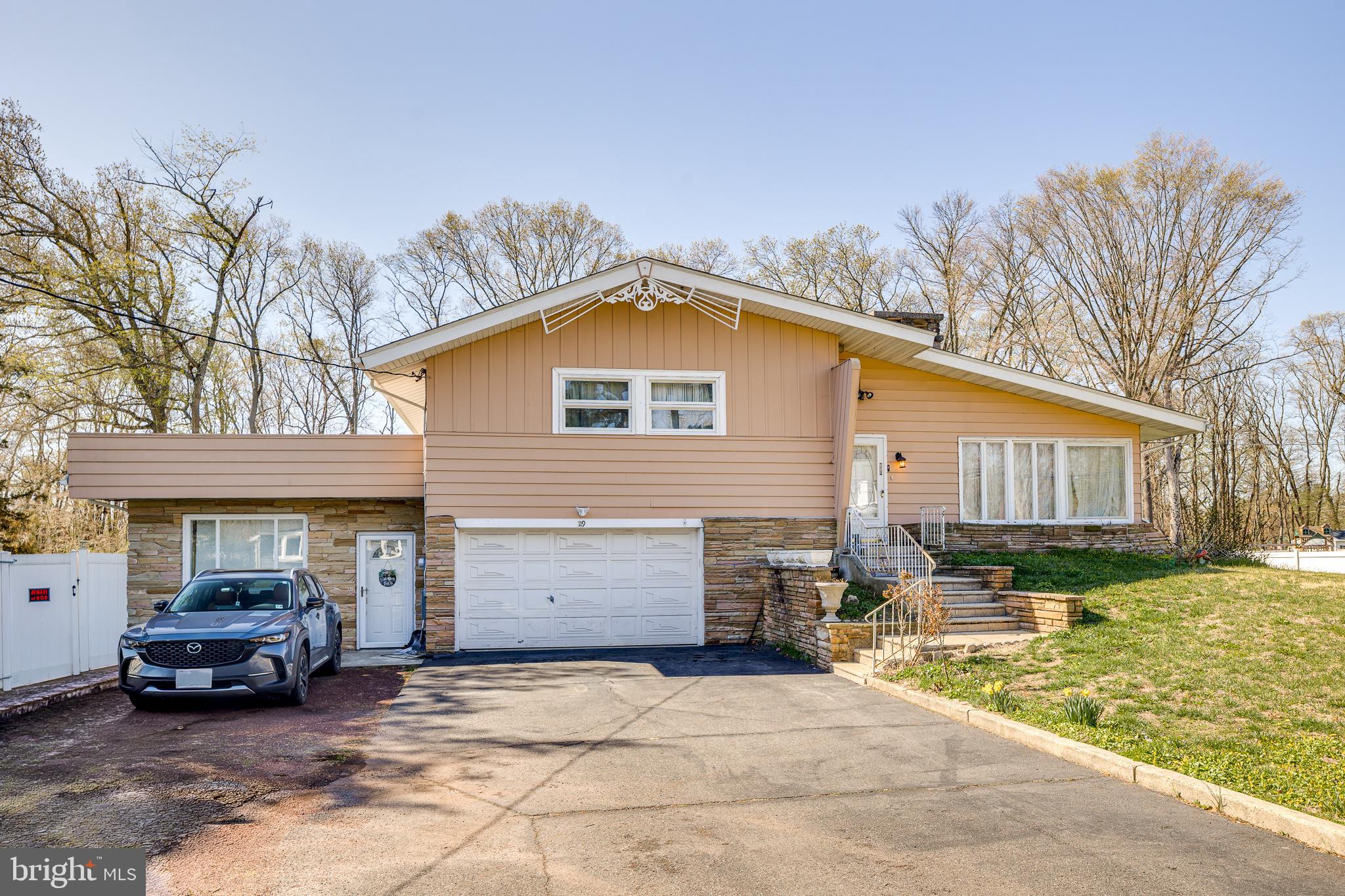 Welcome to this spacious and versatile split-level home in the heart of Mount Laurel, featuring a fully renovated in-law suite and sitting on over half an acre of private, fenced-in land!This property offers exceptional flexibility for multi-generational living, extended family, or potential supplemental income. The attached in-law suite has been completely remodeled, showcasing a brand-new kitchen, updated full bathroom, and two bedrooms, along with its own private entrance—creating a truly independent living space.The main residence maintains its original charm and functional layout, offering three bedrooms and two full bathrooms, with natural hardwood flooring throughout much of the living space. The kitchen provides ample cabinetry, stainless steel appliances, and dedicated dining space, flowing seamlessly into a bright and expansive sunroom filled with natural light and tranquil backyard views.The lower level adds additional living space with a cozy stone fireplace and flexible layout for entertaining, recreation, or relaxation.Step outside to a massive, fully fenced backyard, offering privacy, open space, and endless potential for outdoor enjoyment. A storage shed is included for added convenience.Parking is never a concern with a large driveway that comfortably accommodates 5+ vehicles, in addition to an attached garage.Ideally located near major highways, shopping, and dining, this property combines space, versatility, and location—making it a rare opportunity in today’s market.