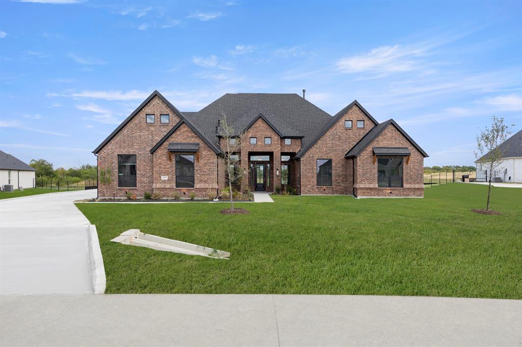 MLS# 21372576 - Built by Kindred Homes - Ready Now! ~ Welcome to the last Sperry floor plan available in Berkshire Estates, zoned to the highly regarded Forney ISD (Willett Elementary and Forney High School). This move-in-ready home offers 5 bedrooms, 4.5 bathrooms, and 4,151 square feet of beautifully designed living space.Set on a private 1.3-acre homesite that backs up to a 12-acre wooded common area, the backyard feels tucked away and peaceful. The covered front porch draws you inside, where twelve-foot ceilings in the foyer, family room, and kitchen create an immediate sense of openness and light. Black-frame windows and an upgraded 8-foot wood front door, and 8’ interior doors keep the home feeling spacious.Just off the entry, a private study with extra windows offers a bright, quiet spot for work or reading. The chef’s kitchen is centered by a huge wood-panel-wrapped island, a 36-inch gas cooktop, double ovens and drawers galore. Luxury plank flooring flows through the family room, kitchen, foyer, hallways, and secondary bedrooms.The family room opens through a 12-foot three-panel sliding glass door onto a covered patio that is pre-wired for speakers and pre-plumbed for an outdoor kitchen. The family room features a direct-vent fireplace with tile surround to the ceiling, while both the media and family room are wired for surround sound.The owner’s suite is complete with dual vanities, a free-standing soaking tub, and a frameless glass shower enclosure. Secondary bedrooms are generously sized with walk-in closets, and a fifth bedroom with its own en-suite bath offers flexibility for guests or multi-generational living. Thoughtful extras like a central vacuum system, tankless water heaters, a half-lite walk-through door from the garage to the side yard, and a full suite of smart-home features (video doorbell, garage openers, HVAC thermostats, electronic front door lock, Wi-Fi booster, and more) make everyday living easy.With more than $204,000 in carefully