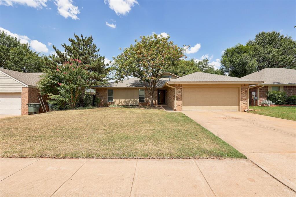 Welcome to your new home in the HEART of Edmond! Just steps from Santa Fe High School and within walking distance to Centennial Park, this home offers both convenience and connection to nature. Nestled on a spacious lot with charming curb appeal, established garden beds await your personal touch. Recent updates include a NEW ROOF (July 2025), fresh carpet, remodeled bathrooms, updated lighting, and more. Step inside to a welcoming entry that flows into the large living room with soaring vaulted ceilings, abundant natural light, a gas fireplace, and built-ins that add both warmth and character. The kitchen and dining area provide plenty of room for entertaining, while the adjoining sunroom extends the living space and offers a perfect spot for indoor-outdoor dining or relaxation year-round. This home features three generously sized bedrooms. The secondary bedrooms boast large closets and share a light-filled bathroom with timeless subway tile and a stylish vanity. The private primary suite at the back of the home includes a spacious closet and spa-like en-suite with double vanities, a walk-in tiled shower, and ample storage—ideal for unwinding after a long day. With multiple gathering spaces indoors and out, this home is designed for both comfort and entertaining. Don’t miss the opportunity to make it yours today!