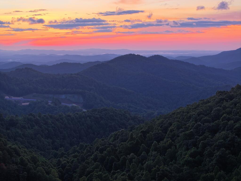 This rugged, private tract offers big-mountain terrain, mature timber, multiple water features & endless recreational potential. 2 towering peaks reach approx 2,480' & 2,800', connected by wooded hollers, rolling hills, & seasonal views extending toward Stuart, Fairy Stone Lake, & Bull Mountain. An old pond tucked deep within a secluded holler is one of the property's most unique features. Per the current owner, this area was once used for Boy Scout camp events, & remnants of an old fishing bench remain near the water's edge. The pond could potentially be enlarged or restocked for private fishing & recreation. 2 creeks flow through the property, adding year-round water, wildlife habitat, & character. Mature oak, poplar, maple, pine, & other hardwoods cover the mountains, while old logging roads provide access throughout the property & could be repurposed for hiking, horseback riding, mountain biking, ATV riding, & hunting. Abundant wildlife sign includes established deer travel corridors, with whitetail deer, black bear, turkey & other mountain wildlife inhabiting the area. Multiple locations offer inspiring seasonal mountain views, while the property's elevation & varied terrain create numerous potential homesites. Build a small cabin for a private mountain retreat, create an off-grid getaway, establish a basecamp, hunt, fish, hike, ride trails, or simply enjoy owning a substantial piece of the Blue Ridge Mountains. The property is approx 8 min to downtown Meadows of Dan & Auberge Primland Resort, mere minutes to Lover's Leap, & approx 18 min to downtown Stuart. Conveniently located near the Blue Ridge Parkway, Fairy Stone State Park, & the outdoor recreation of Patrick County. If you're searching for unrestricted mountain land, hunting & recreational acreage, timberland, a private pond, mountain property, or cabin land in Patrick County/Meadows of Dan, this 82+/- acre tract offers the space, privacy, & freedom to create your own mountain retreat. Shown by appt,