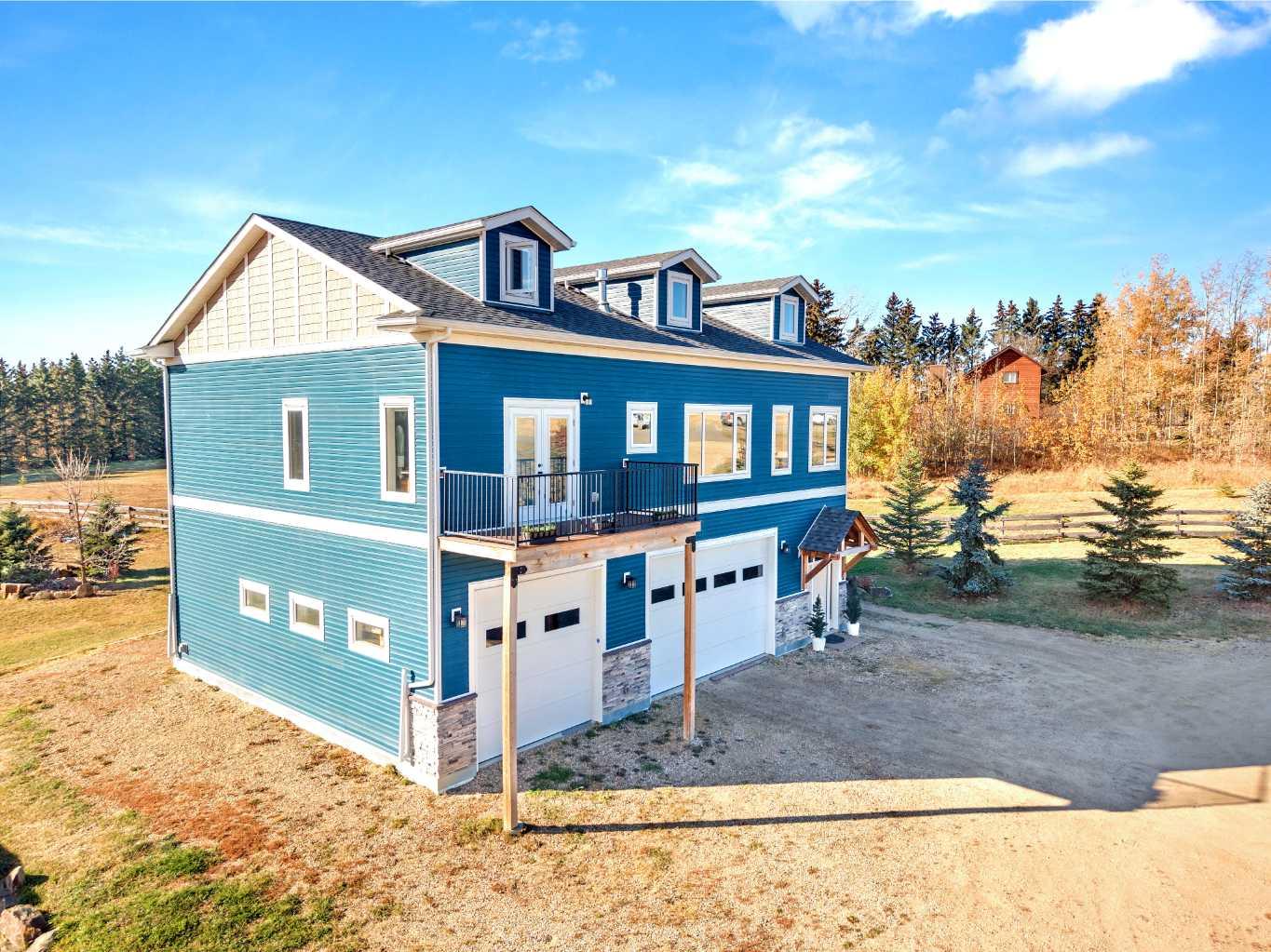 Just in time for the holidays, this home’s $25,000 price improvement is an early Christmas present for the buyer who’s been waiting for something special. Picture the season with more value, more space, more privacy, and more of that country lifestyle. Tucked onto 3 serene acres just north of Sylvan Lake, this property gives you the rare mix of freedom, space, and connection. Downtown is just 7 minutes away, Red Deer is only 20, but it feels like a different world in Silver Springs.For anyone who lights up at the idea of a dream garage, this one’s something else. Heated by gas or the wood stove, with 13-foot ceilings, drive-through doors, a half bath and nearly 1,300 square feet to play with, it’s more than a garage. It’s a shop, a retreat, a space to build, fix, create, workout or just hang out.Upstairs, the home is a pinch of country, but heavy on luxury. Think wide-open spaces, vaulted ceilings, skylit dormers, and a show-stopping stone fireplace. The kitchen pops with white cabinetry, quartz waterfall counters and sleek black stainless appliances. From the main living area, step onto the composite deck and breathe in the Southwestern view of treetops, big skies, and glimpses of the lake.The primary suite is its own little hideaway, complete with a walk-in closet, makeup desk, four-piece ensuite, and a private patio perfect for morning coffee or an evening nightcap. Two more bright bedrooms and a stylish main bath with stand-alone tub and separate shower offer comfort for kids or guests. If the adults all have their space, then the upper loft is the ultimate kid zone, ideal for a playroom, homework space or sleepovers.Outside, everything has its place. Three matching sheds, RV parking with power, a firepit by the seasonal pond, and mature spruce trees that offer shelter and privacy, but could open up for even more of that lake view.This home is loaded with thoughtful extras: central A/C, water softener, central vac, outdoor shower, Sonos system, smart lighting, plugs, thermostats, all the little things that make life smoother and more connected. A paved road leads you straight to the property, making every drive in feel like a breath of fresh air.Whether you're a young couple, a hands-on creator, or someone craving more sky and stillness, this home isn't just about square footage,  it's about breathing room, balance, and the kind of place that sparks inspiration.