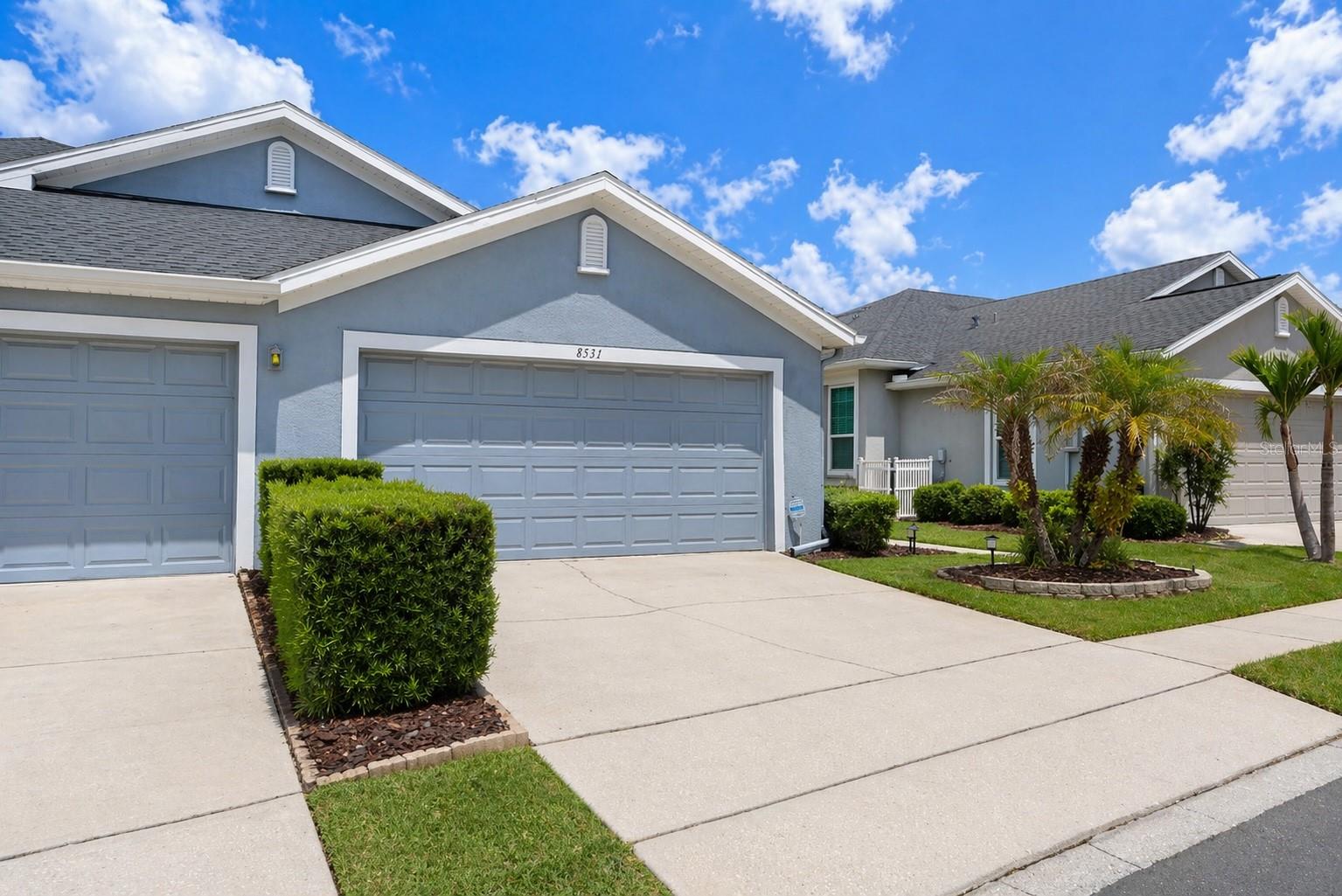 Welcome to this beautifully maintained villa located in the gated community of Westmont Oaks in Tampa, located in close proximity to the Westchase area. Offering 2 bedrooms, 2 bathrooms, and a spacious 2-car garage, this home combines comfort, functionality, and low-maintenance living in a prime location. A private side-entry front door welcomes you into a bright and open living space featuring rich wood flooring, plantation shutters, and a flexible layout with both a main living area and additional sitting space—perfect for relaxing or entertaining. Just off the entry, a generously sized formal dining area flows seamlessly into the kitchen, which is equipped with stainless steel appliances, tile flooring, a pantry, and a cozy breakfast nook. The thoughtfully designed split floor plan offers both privacy and comfort. The primary suite is tucked away on one side of the home, creating a peaceful retreat with wood flooring, plantation shutters, and a spacious walk-in closet with custom built-ins. The updated en-suite bathroom features dual granite vanities and a zero-entry, accessible-friendly walk-in shower. On the opposite side of the home, the secondary bedroom offers wood flooring, ample closet space, and convenient access to a full bathroom with a granite vanity and tub/shower combination—ideal for guests or a home office setup. Nearby, the interior laundry closet includes cabinet shelving for added storage [Washer/Dryer included] and leads directly to the oversized 2-car garage. Sliding glass doors from the living area open to a private outdoor patio, complete with vinyl privacy fencing—creating the perfect space for outdoor dining or enjoying Florida living year-round. Westmont Oaks is known for its beautifully maintained grounds, highlighted by majestic oak trees and lush landscaping that create a serene, park-like setting throughout the community. Residents enjoy a true maintenance-free lifestyle, with the HOA covering exterior paint, roof, and landscaping. Uniquely, the HOA also carries a Master Insurance policy, meaning homeowners typically only need an HO3 policy for interior coverage. Residents also enjoy access to a community pool, all while being conveniently located near the Veterans Expressway, making for an easy commute to Tampa, shopping, dining, and all that the Greater Tampa Bay metro has to offer it's residents.
