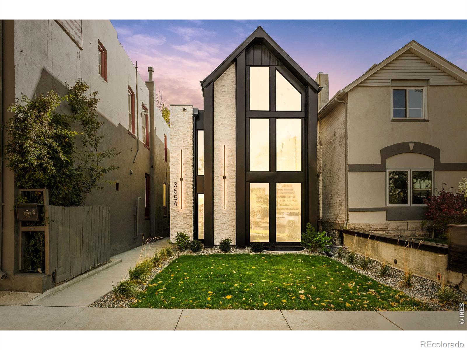 Modern architecture and refined craftsmanship define this newly constructed residence in Denver's LoHi neighborhood. A bold exterior of clean lines and mixed materials introduces luminous interiors designed for natural light, functionality, and elevated living. Spanning approximately 3,600 square feet, the home offers seamless indoor-outdoor connection and an intelligent floor plan ideal for modern lifestyles. The main level centers around an open-concept living and dining space framed by floor-to-ceiling windows and anchored by a sculptural staircase. The chef's kitchen features a waterfall-edge quartz island, fully integrated appliances, extended prep counter with secondary sink, custom cabinetry, and designer lighting. Sliding doors open to a private courtyard that extends entertaining and everyday living outdoors. A dedicated study, entry foyer with built-in storage, and mudroom with access to the detached EV-ready two-car garage complete this level. Upstairs, the primary suite creates a tranquil retreat with a large custom walk-in closet and a spa-inspired five-piece bath finished in quartz, stone, and designer tile. A secondary suite and a convenient laundry room complete the upper level. The lower level expands the living space with a generous recreation room, guest suite, wet bar, and ample storage. At the top, a 740-square-foot rooftop deck provides panoramic 360-degree city and mountain views for relaxation or entertaining. High-performance windows, energy-efficient systems, and durable finishes ensure year-round comfort and sustainability. Located 0.2 miles from Denver favorites including Root Down, Little Man Ice Cream, Wildflower, and Acova, and under 0.5 miles from neighborhood parks, boutique fitness studios, and coffee shops, this residence offers proximity to the best of LoHi's dining, shopping, and entertainment. Every space reflects a purposeful approach to modern design, architecture, energy consciousness, and a distinctly Denver aesthetic. New C