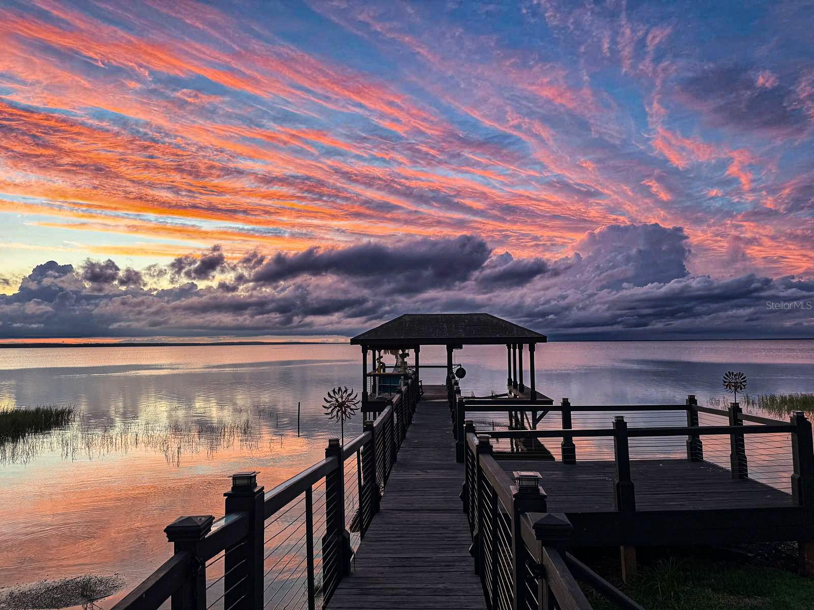 Completely Remodeled Waterfront Luxury Home – Boater’s Paradise on Lake Apopka

Experience the ultimate in lakefront living with this stunning, turnkey home on Lake Apopka in Winter Garden. Boasting over 3,700 sq. ft. of beautifully remodeled living space, this 4-bedroom, 3.5-bathroom residence combines modern luxury with waterfront charm, offering breathtaking sunrise and sunset views every day.

Every inch of this home has been meticulously upgraded with nearly $450,000 invested in recent renovations, creating a move-in-ready oasis with high ceilings, spacious open-concept living, and designer finishes throughout. Gorgeous porcelain tile and hardwood floors flow seamlessly across two stories, complemented by abundant natural light from all-new, upgraded windows.

The gourmet kitchen is a chef’s dream, featuring quartz countertops, a large island with built-in cabinetry, stainless steel appliances, a backlit quartz bar, and a modern backsplash. Entertain effortlessly in the expansive dining room and living room framing incredible lake views.

The master suite is a serene retreat with two walk-in closets, an oversized Jacuzzi bathroom, and stunning water vistas. Each bedroom boasts lake views, while a second-floor guest bedroom offers privacy, a separate bathroom, and noise-reducing flooring—perfect for a home theater or office. A dedicated office/den at the entrance is ideal for remote work or study.

Outdoor living is exceptional with two enclosed and screened patios on the first and second floors, providing panoramic lake views. Boaters will love the expansive deep-water dock with lift and the fun Margaritaville-themed bar. The backyard features a newly resurfaced saltwater pool with a new pump, fully fenced secure yard for kids and pets, fruit trees and mature, landscaped greenery creating a private oasis.

Additional highlights include new windows, new HVAC, new solar panels, smart thermostat, upgraded irrigation, and a two-car garage with built-ins. Located in a quiet, family-friendly gated community with golf-cart-friendly streets and direct access to the scenic West Orange Trail.

Enjoy Winter Garden’s historic downtown just minutes away, with A-rated schools, shopping, dining, and the famous weekend farmers market. Only 20 minutes to Downtown Orlando and close to Disney, Universal, and major highways without the traffic.

This is more than a home—it’s a boater’s and fisherman’s paradise, a lakefront retreat, and a perfect family haven all in one. Don’t miss this rare opportunity to own a completely remodeled luxury waterfront home with unmatched views and lifestyle amenities on Lake Apopka, offering over 30,000 acres of endless water fun! Price can be reduced by $40,000 if the buyer is willing to assume a low-rated solar panels loan!