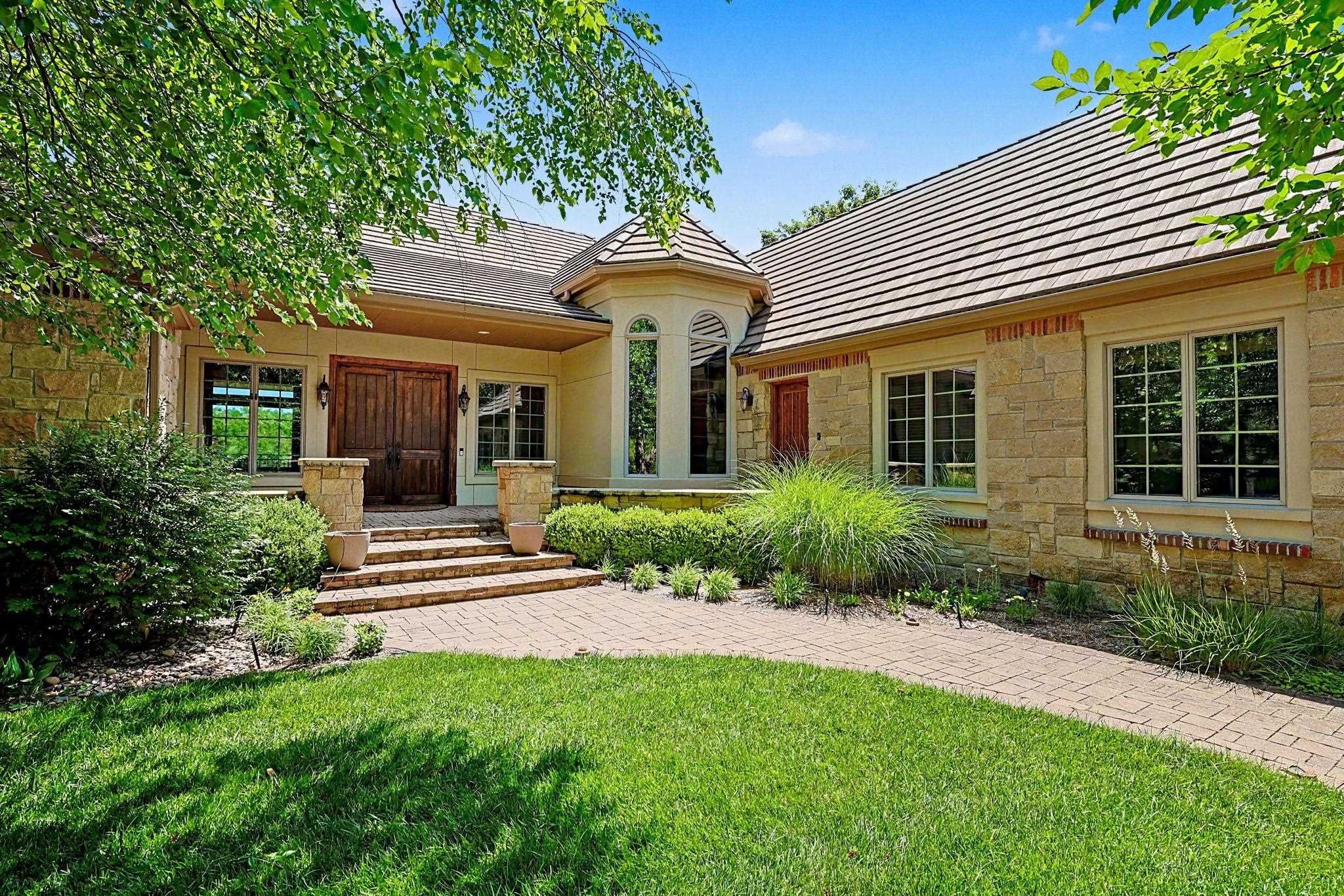 This beautiful one owner home in spectacular Flint Hills National has so much to offer.  The stone and stucco exterior nestled among a variety of mature trees combine to create both an upscale and inviting curb appeal. Large windows on both the front and back of the home take full advantage of the beautiful surroundings, including great views of the expansive common area and lake behind the home.  Two main floor living areas, two dining areas and a great kitchen, plus family and game room areas in the walkout basement combine to create great space for entertaining or just relaxing with your family.  Very flexible floor plan with 5 bedrooms including a 21x15 ensuite with zero entry shower, elevator access and separate exterior door close by making it a great guest suite, exercise room or office.  Incredible woodwork throughout this home creating a warm and rustic, yet refined look and feel.  This spacious .84 acre home site feels even larger with no homes across the street and large common area behind.  Just a short golf cart ride to the nationally recognized Flint Hills National Golf Club.  Andover schools!