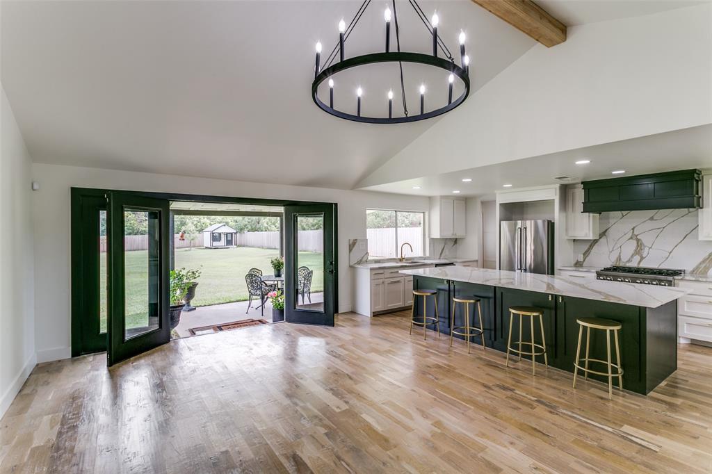 Beautifully Renovated 3-Bedroom 2 Bath Home with Endless Possibilities! Step into this tastefully renovated home featuring real wood floors, custom cabinetry, sleek quartz countertops, and a massive kitchen island.  The open floor plan flows seamlessly through the main living area, where vaulted ceilings and natural light from a wall of doors and windows create an inviting atmosphere. The spacious living room opens directly to a gourmet kitchen equipped with stainless steel appliances, 36 inch ZLINE Stainless Steel Gas Range, counter depth refrigerator and built-in wine fridge ideal for both everyday living and entertaining. Custom-remodeled bathrooms add a touch of luxury, with high-end finishes and thoughtful design throughout.  Situated on the front of the nearly three quarter acre lot, this home offers a rare opportunity: the potential to live in the home while you build your dream home behind the existing structure. New construction plans for a beautiful 1 story costal elevation, site plan, and all engineering and permits are complete and have been approved by the City of Colleyville, unlocking a variety of options for expansion, investment, or multi-generational living. (New construction floor plan, elevation and site plan are online in document center) Whether you’re looking to move in and let family and pets enjoy the huge lot with 8 foot privacy fence and two additional Ulrich Barn buildings for storage or build out your vision; this home delivers comfort, style, and flexibility in one exceptional package.