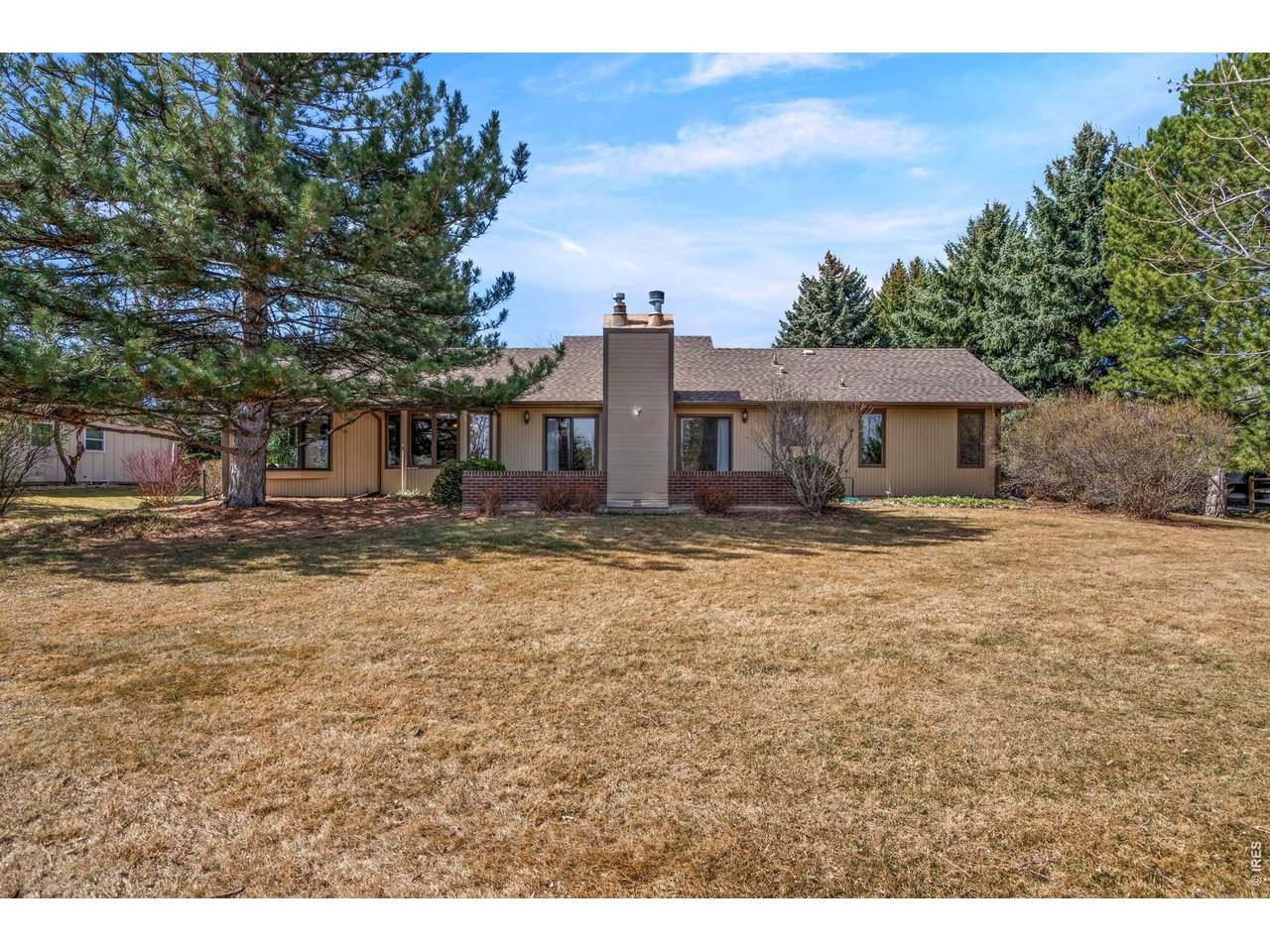 Nestled in coveted The Ridge neighborhood, this beautifully maintained ranch-style home offers 5 bedrooms, an office, and 3 bathrooms on a spacious half-acre lot backing to a serene and peaceful greenbelt. Ideally located in SW Fort Collins, you'll enjoy close proximity to Cathy Fromme Natural Area, Spring Canyon Park, Horsetooth Reservoir, and Lory State Park, offering endless opportunities for outdoor recreation. The gourmet kitchen is a chef's delight, featuring top-of-the-line appliances including a Sub-Zero refrigerator, granite countertops, and custom cherry cabinetry. Natural light is abundant, enhanced by skylights and inviting living spaces. A spacious formal dining room adds to the home's charm and functionality. The main level features the primary bedroom with an en suite bath and an updated secondary bathroom. One of the home's most special features is the stunning sunroom complete with a mini-split for temperature control and a convenient water spigot for plant care. This light-filled space is designed to bring the outdoors in. Surrounded by windows, it provides a peaceful setting to enjoy the beauty of every season year-round. Whether sipping your morning coffee, enjoying house plants, or utilizing the space as a home office, the picturesque views of the lush backyard and open greenbelt provide a captivating and tranquil backdrop. A stunning spiral staircase connects the space to the finished basement, adding character and functionality. The spacious basement offers a family room including a wet bar, two additional bedrooms, a generous bathroom, and an office. Step out back to enjoy the spacious patio and well-established, mature landscaping, including mature trees and black raspberry bushes. Opportunities like this are rare! Don't miss your chance to own a truly special home in The Ridge!