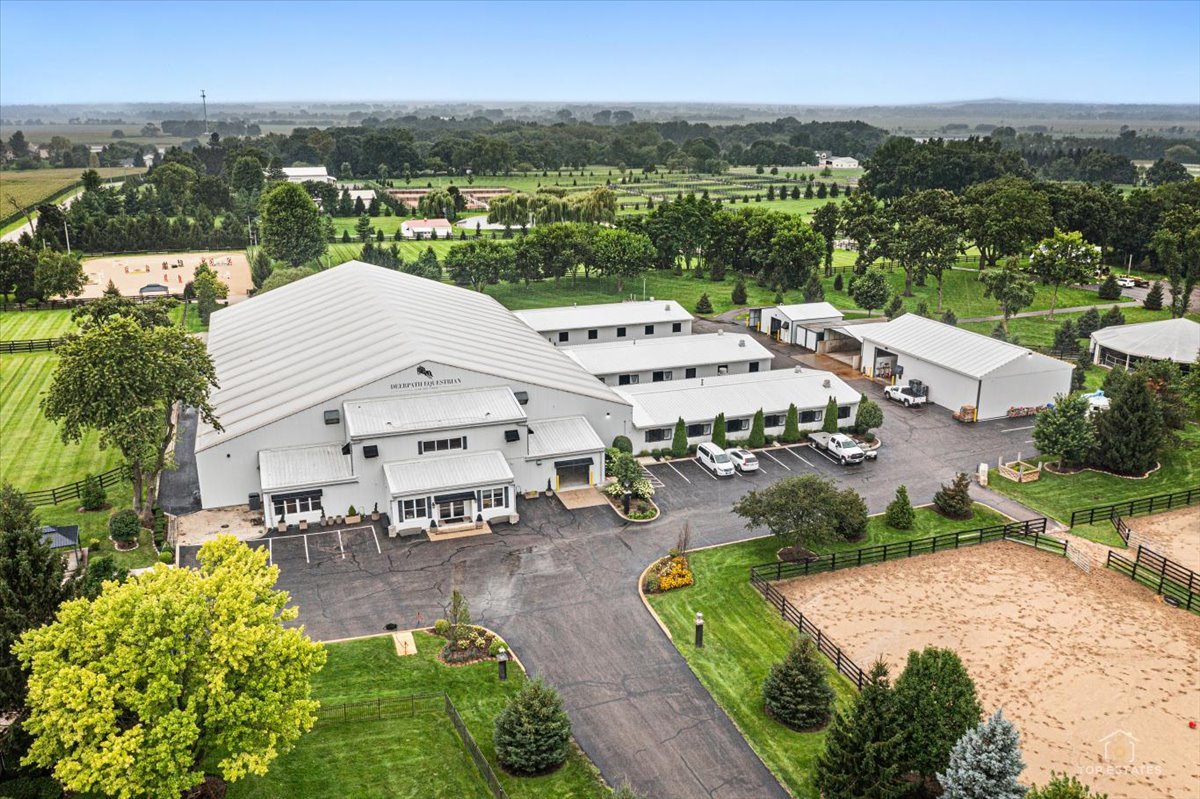 A truly exceptional world-class equestrian facility, this remarkable property offers an unparalleled combination of scale, sophistication, and purpose-built amenities, creating an extraordinary opportunity for a premier equestrian operation, private estate, training facility, boarding business, or event venue. At the heart of the property is an impressive 45,000-square-foot stable featuring 29 premium windowed stalls, a 20,000-square-foot indoor arena with synthetic fiber footing, 10 interior and 2 exterior wash and grooming stalls, 3 tack rooms, a feed room, central vacuum system, laundry facilities, and radiant heat throughout. The facility was thoughtfully designed with both horses and riders in mind, offering a climate-controlled lounge with ice maker, dishwasher, and true double refrigerator, second-floor viewing room with Ashly sound system, 2 private offices, commercial-grade bathrooms and shower room, control room, and security system. Exceptional equine amenities include a HorseGym treadmill, Hudson AquaPacer, Vita Floor Stall, solarium, and a four-season 6-horse Eurosizer. The grounds provide 24 fully irrigated paddocks with grass and sand, a spectacular 9-acre irrigated derby field, and an outdoor arena with a gazebo-style viewing area. Five renovated residences add tremendous versatility for owners, staff, guests, or additional income. A separate heated 5,000-square-foot event barn creates even more opportunity, complete with a commercial-grade kitchen, bathrooms, upper loft equipped with sound system for DJs or live bands, Atlas Brand lift, custom bar with 2 drink wells, laundry room, and covered patio overlooking the beautifully maintained grounds. Seven additional structures, including pole barns, storage buildings, a manure port, pumping stations, and other support facilities, complete this remarkably well-equipped property. Ideally located less than 60 minutes from downtown Chicago and within convenient reach of HITS Chicago, Ledges, Traverse City, Kentucky Horse Park, and other premier equestrian destinations, this is far more than a horse property-it is a fully developed equestrian destination with the scale, infrastructure, and flexibility to support a world-class operation. Properties of this caliber and scope rarely become available.