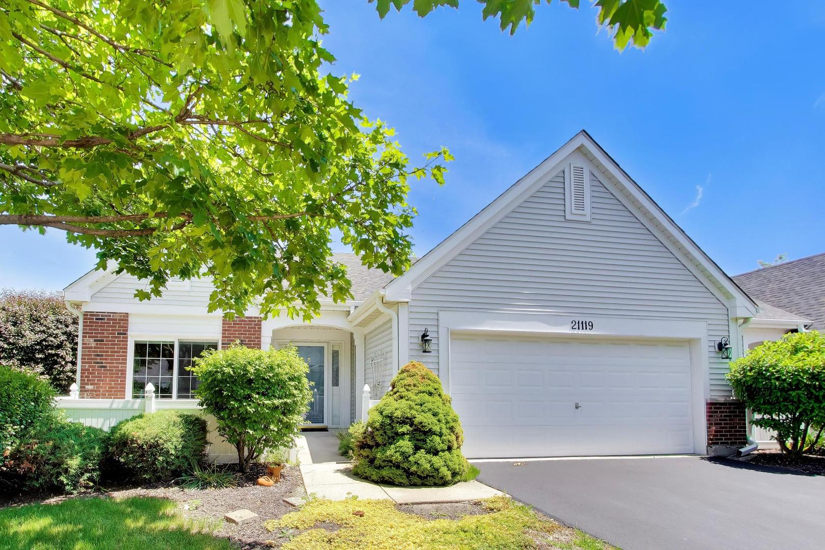 Rare End Unit Augusta model in Carillon with full finished basement, 3 bedrooms, 3 full baths, 2-car garage, 9-ft ceilings, main-level living, and first-time-on-market original-owner care. This incredibly well-maintained villa townhome offers one of the harder-to-find layouts in Plainfield's sought-after Carillon 55+ gated community. Augusta models with full basements are rarely available, and this one stands out with a fully finished lower level featuring a large bedroom, full bathroom, walk-in closet, recreation space, and generous storage.    The main level offers an easy-flow floor plan with a spacious living room, separate formal dining room, large eat-in kitchen, first-floor laundry, and a generous primary suite with walk-in closet and private bath featuring a soaking tub plus separate shower. Sliding glass doors off the living room open to the deck, with views of the side yard and backyard that create a more open, private feel than many attached homes.    Additional highlights include distinctive Dutch- and French-style basement windows with hand-laid brick detailing, adding character and natural light to the finished lower level. Enjoy low-maintenance living in Carillon with 24-hour gated security, clubhouse, indoor and outdoor pools, fitness, tennis, pickleball, bocce, activities, and three 9-hole golf courses with pro shop. Fantastic location near shopping, parks, recreation, health care, restaurants, and expressways.