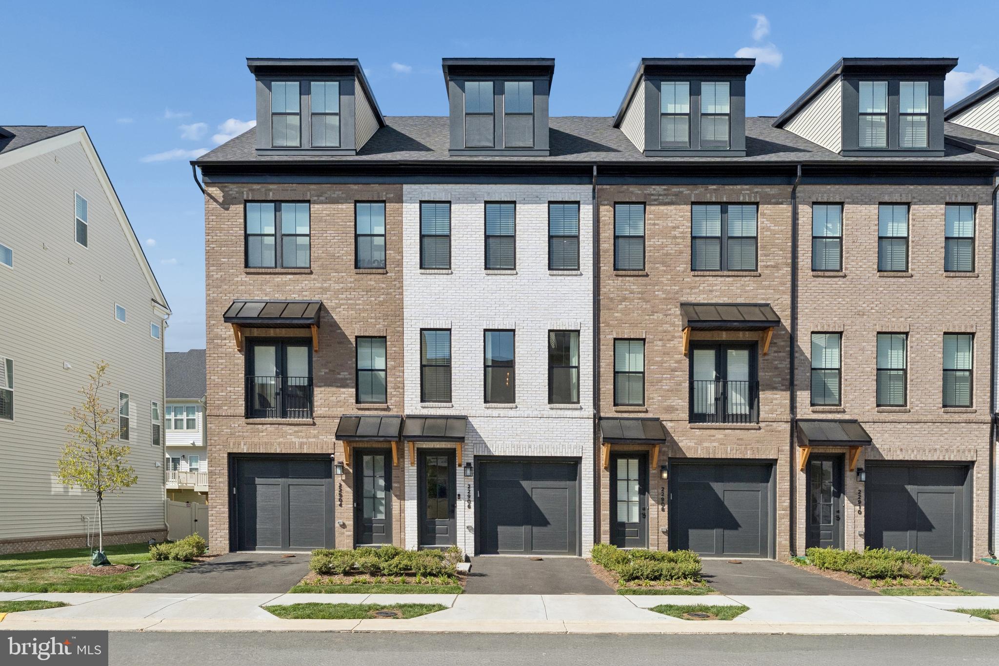 Almost new, built in 2025, this 3-level townhome offers modern finishes and flexible living space in the heart of Brambleton. The entry level features a tandem 2-car garage with direct access to the yard—ideal for outdoor enjoyment or pets.The main level showcases an open-concept layout filled with natural light. The upgraded kitchen includes quartz countertops, a custom backsplash, matte black fixtures, pendant lighting, and an extended island perfect for everyday living and entertaining. The living area opens to a 12x12 deck for added outdoor space.Upstairs, two bedrooms each feature en-suite baths. The primary suite includes a bay window bump-out, dual closets, and a modern bath with updated finishes. The secondary bedroom offers convenient access to its own full bath.The top level provides additional flexibility with a third bedroom and loft space—ideal for a home office, media room, or guest suite. A mini-split A/C system ensures comfort on this level.Additional highlights include contemporary railings, modern hardware throughout, and thoughtful design across all three levels. Located just minutes from Brambleton Town Center, with access to shopping, dining, trails, pools, and community amenities.
