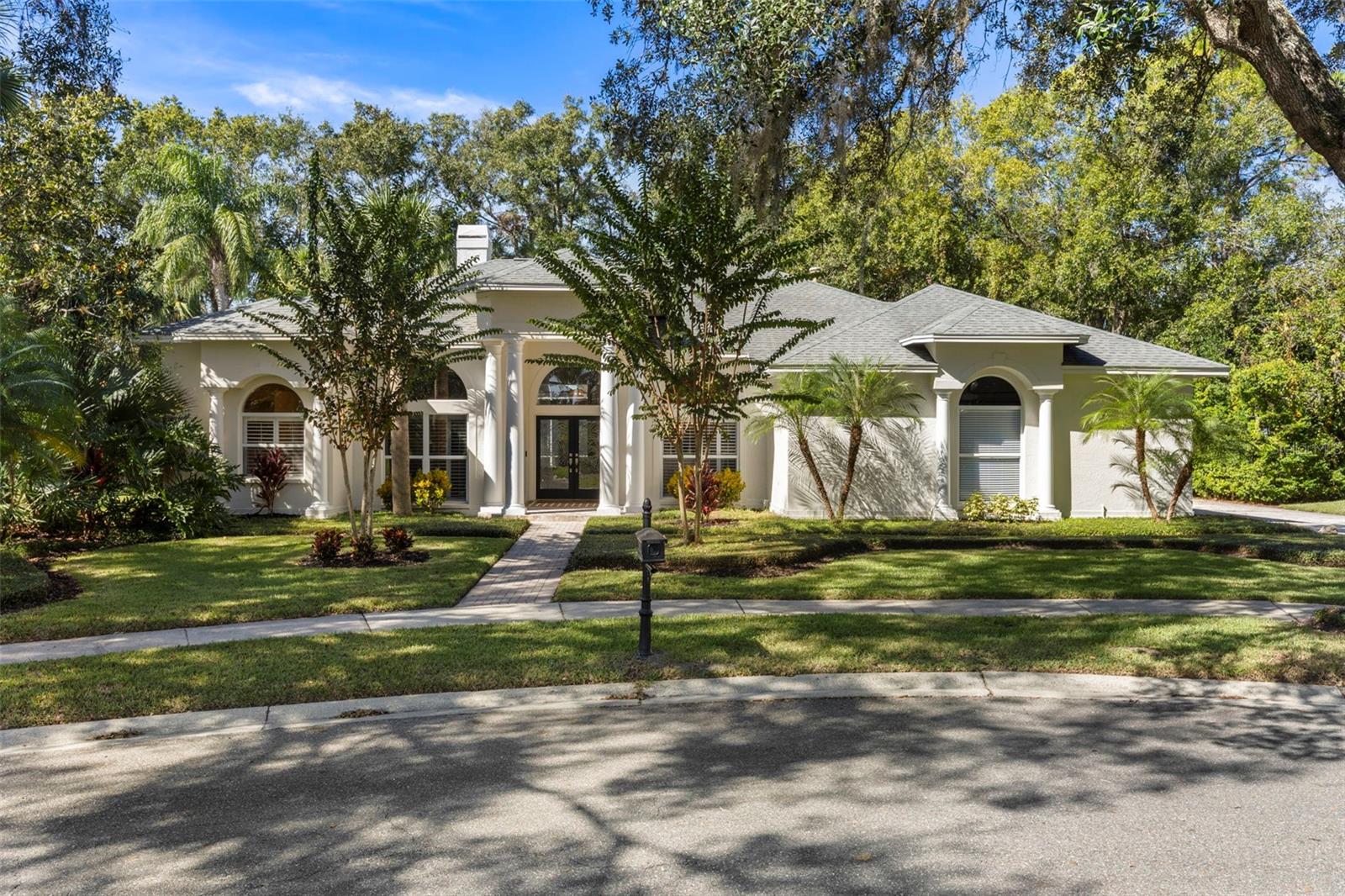 Introducing an impeccably maintained estate home nestled within the prestigious, gated enclave of Huntington at Tampa Palms. Perfectly positioned on a pristine conservation lot at the end of a serene, tree-lined cul-de-sac, this exceptional one-story residence offers the ultimate in privacy, elegance, and convenience—with only one neighboring home.

Spanning 3,031 square feet of thoughtfully designed living space, the home features 4 bedrooms, 3.5 baths, a private study, and an oversized three-car garage. Inside, sophisticated architectural details abound, including volume ceilings, transom windows, French doors, and expansive pocket sliders that seamlessly blend indoor and outdoor living.

Every interior finish has been designer-curated, showcasing hardwood flooring, custom millwork, quartz and granite surfaces, porcelain tile, and upgraded lighting and fixtures throughout. The split-bedroom layout ensures comfort and privacy, with each room offering serene views of the preserve or lanai.

The gourmet kitchen is a culinary masterpiece—appointed with premium GE stainless-steel appliances, a gas range, custom wood cabinetry, quartz “concrete-finish” countertops, a porcelain tile backsplash, and a central island ideal for gathering.

Designed for both relaxation and entertainment, the expansive lanai opens to a sparkling pool and raised spa overlooking the tranquil preserve. A summer kitchen with built-in gas grill completes this idyllic outdoor retreat.

Additional highlights include a side-load three-car garage with extended depth, 8’ foot garage doors, and high ceilings. The third bay—currently enclosed—offers flexibility for conversion to air-conditioned living space. A fenced dog run adds convenience for pet owners.

Ideally located just minutes from USF, Moffitt Cancer Center, the VA and Florida Hospitals, YMCA, Tampa Palms Golf & Country Club, I-75, and regional shopping and dining, this remarkable residence delivers the perfect blend of luxury, privacy, and lifestyle.