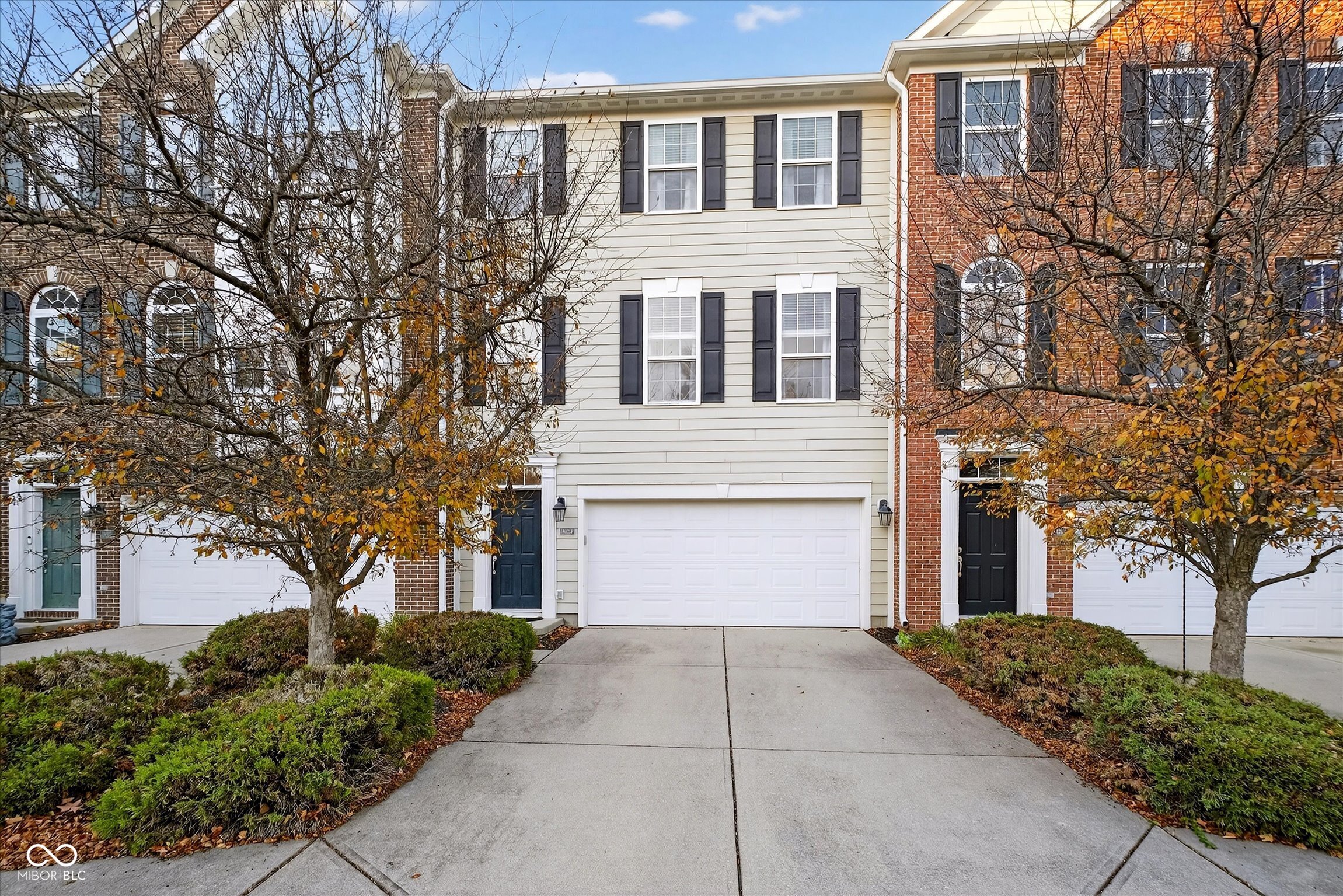 Sophisticated Townhome in the Heart of Fishers  Welcome to a home where sophistication meets ease, and every detail feels intentionally designed for modern living. Nestled in one of Fishers' most desirable locations, this beautifully updated townhome embodies refined living with a sense of calm and connection.  The open-concept layout is spacious, inviting, and filled with light. Rich LVP flooring flows seamlessly through the main areas and staircase, setting the tone for a modern, polished aesthetic. At the heart of the home, the gourmet kitchen shines with a center island, stainless steel appliances, and ample space to gather. Just beyond, the great room's gas fireplace creates a cozy focal point for evenings spent unwinding or entertaining with friends.  A sliding door opens to a private balcony overlooking a wooded backdrop and gentle creek, offering a peaceful escape for morning coffee or evening relaxation.  On the upper level, the primary suite serves as a serene retreat with vaulted ceilings, treetop views, and a spacious walk-in closet. The renovated en suite bath offers a spa-like feel with a dual-sink vanity, tile flooring, and a glass walk-in shower. A second primary suite, complete with vaulted ceilings, dual walk-in closets, and a beautifully updated bath-provides a perfect guest haven or quiet workspace.  On the main level, a versatile bonus room with a full bath and patio access offers endless possibilities, from a cozy media room to a guest suite or home office with a view.  With all ground maintenance included, life here is as effortless as it is elegant, just steps from the Nickel Plate Trail and minutes from Fishers' vibrant dining and entertainment.  This townhome captures the essence of sophisticated, low-maintenance living, blending luxury, privacy, and convenience in perfect harmony.