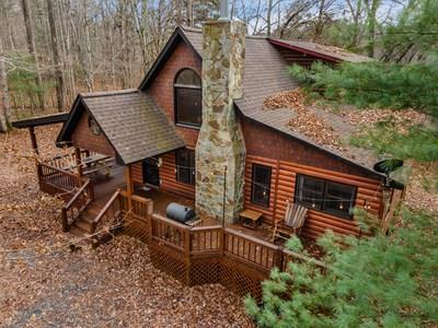 Discover the perfect blend of rustic character and modern comfort in this beautifully crafted Chalet-style cabin, offering 3 bedrooms, 3 bathrooms, and a spacious loft ideal for extra sleeping space, a game room, or a cozy reading nook. Whether you're seeking a personal retreat or a proven income-producing short-term rental, this property delivers on every level.  Nestled on a private, level to gently sloping lot, the land itself becomes part of the experience—easy to enjoy, effortless to maintain, and ideal for maximizing outdoor living. Gather around the fire pit, host outdoor meals, or simply breathe in the mountain air surrounded by nature.  Step inside to an inviting interior highlighted by granite countertops, warm wood tones, and a wood-burning fireplace that sets the mood for unforgettable mountain evenings. The master suite on the main level adds convenience and privacy, while additional bedrooms and the loft ensure plenty of space for guests.  After a day exploring the mountains, relax and unwind in your private hot tub, perfectly positioned to take in the peaceful surroundings.  Whether you're investing, retreating, or both—this cabin offers the mountain lifestyle people dream about. Turn-key, charming, and ready for its next chapter. Don't miss this one!