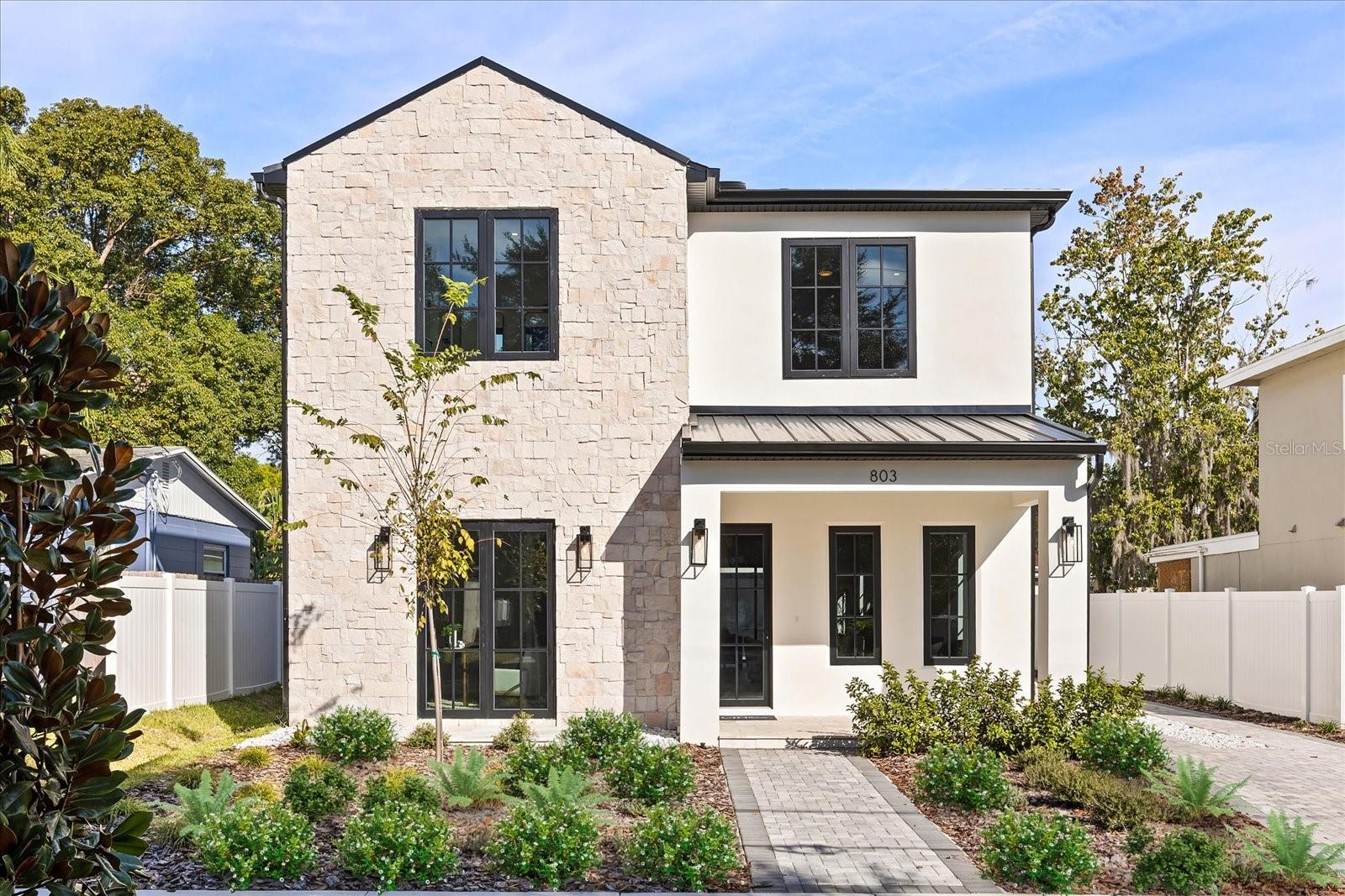 A newly constructed luxury home in the heart of College Park, this property blends modern craftsmanship with the classic charm of one of Orlando's most beloved neighborhoods. The main level unfolds with an effortless sense of openness, where the living room, dining room, and family room flow seamlessly around a chef's kitchen appointed with stone counters, a designer range hood, and a suite of built-in appliances including a wine refrigerator. A private bedroom with a full bath on this level offers ideal flexibility for guests or a dedicated workspace.The second floor is designed for comfort and privacy, beginning with a serene primary suite featuring a generous walk-in closet and a spa inspired bath.Three additional bedrooms provide abundant space for family and visitors, while a loft and an upstairs laundry room add everyday convenience to the thoughtful layout. Throughout the home, engineered hardwood and porcelain tile floors combine durability with beauty, and features such as zoned climate control, custom accents, and ample storage showcase the quality of construction.Outdoors, the lifestyle continues with a covered living area, an outdoor kitchen, and a landscaped yard ideal for quiet evenings or weekend gatherings. A long driveway leads to a rare detached garage that adds both convenience and private covered parking. Sidewalk lined streets connect you to the energy of College Park, where local dining, boutique shopping, parks, and the upcoming Packing District enrich every day.Move in ready and meticulously designed, this luxury home offers a refined way of living in a location that brings the best of Orlando to your doorstep