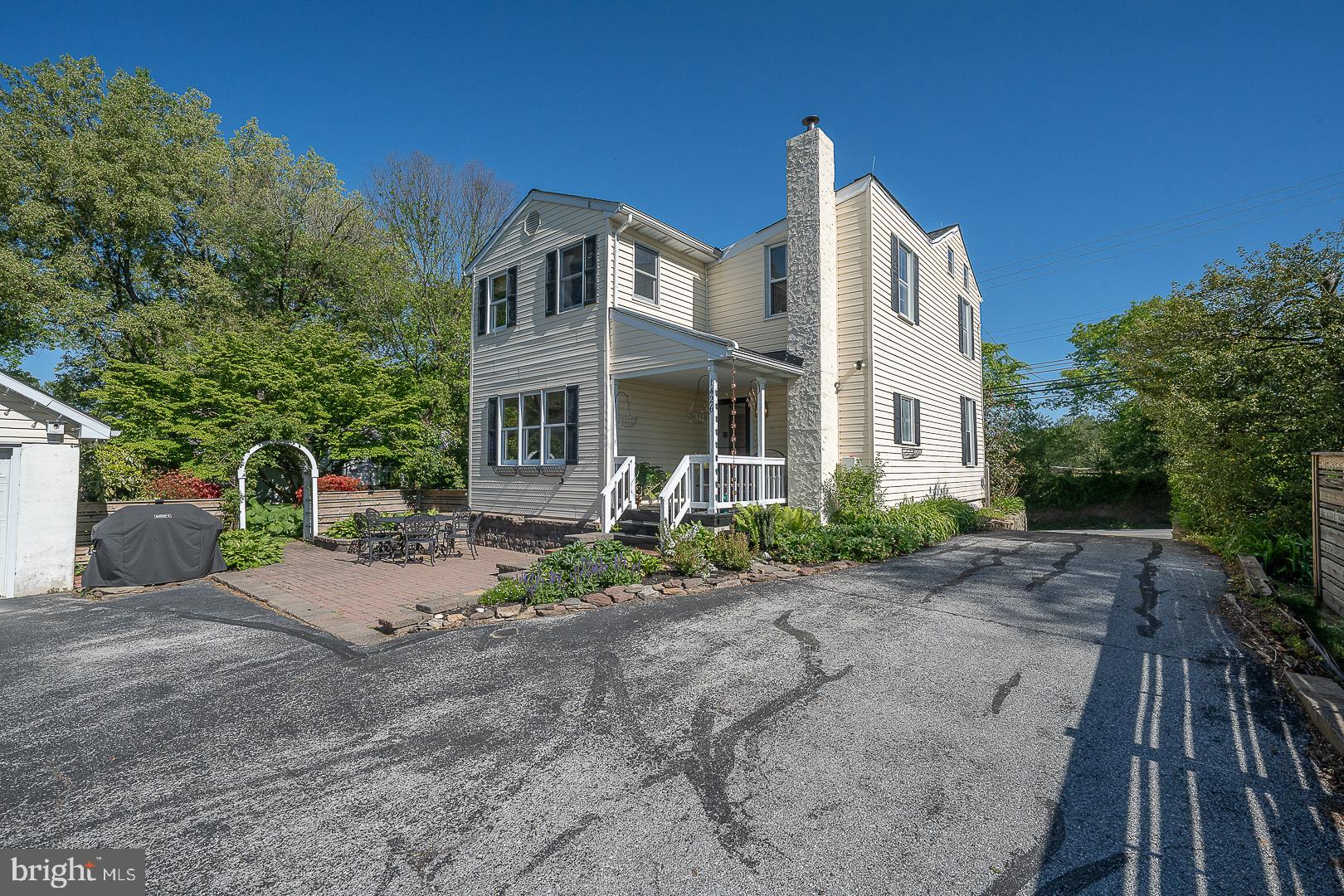 Nestled in the historic village of Marshallton, this stunning property offers timeless charm, beautiful updates, and an exceptional setting on nearly ¾ of an acre. This expansive lot that stretches from Strasburg Road all the way to Clayton, features lush landscaping, a spacious driveway (enough for 5+ cars) , a detached two-car garage with great storage, picturesque gardens, and a beautiful paver patio with arched arbor entry—perfect for entertaining or relaxing while enjoying the peaceful scenery. Inside, you’ll immediately appreciate the character and warmth of the home, highlighted by gorgeous hardwood flooring, including original wide plank floors. The kitchen features recessed lighting & stainless appliances,  has been updated with painted cabinets, butcher block countertops , new hardware, a new disposal & a modern farmhouse sink. Notice the pantry here for extra storage. The spacious family room features a wood-burning fireplace with elegant white brick surround, mantel, crown molding, and custom built-in cabinetry. Just off the family room is a newly renovated powder room and convenient first-floor laundry closet. The dining room is filled with natural light and accented with chair rail molding, while the expansive family room showcases an impressive wall of built-in bookshelves and cabinetry. Upstairs, you’ll find three bedrooms, two full bathrooms, and walk-up attic access.  The primary suite features a walk-in closet, abundant natural light, and a beautifully remodeled bathroom with double vanity and elegant tilework. The hall bath is generously sized and includes beadboard paneling and a newer vanity. The second bedroom offers two closets and a charming recessed window seat, while the third bedroom, features custom shelving, a closet, and direct attic access. Additional highlights include central air,  roofs on both the home and garage (replaced in 2015), a covered rear porch, public water and sewer, and a basement for storage. The location is truly unbeatable. Enjoy walking distance to local favorites including Four Dogs Tavern, Marshalton Inn & the Broad Street Grille is a 5 minute drive away. Close proximity to great restaurants, hiking trails & golf courses. Downingtown School District while the West Chester borough is a 10 minute drive away. This is an amazing place to call home - meticulously maintained!