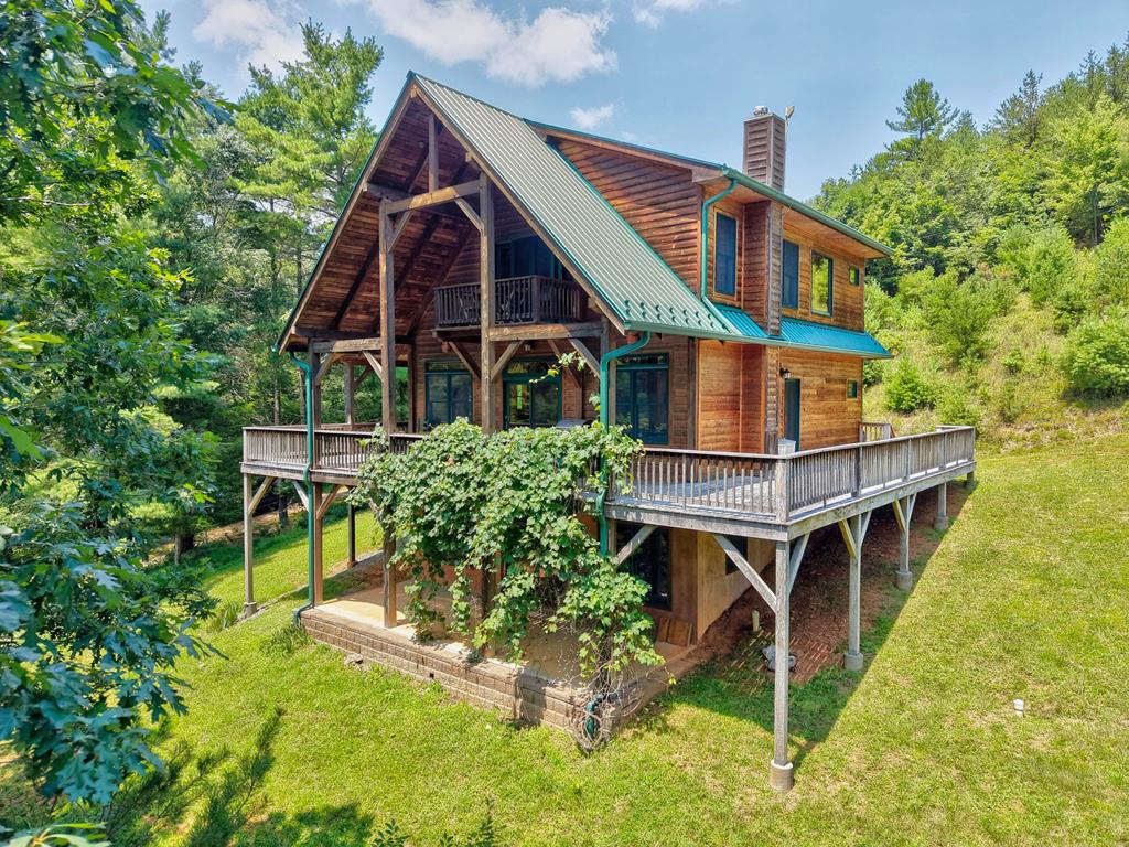 High in the Blue Ridge Mountains, this exceptional custom-built, cedar-sided cabin borders Jefferson National Forest and features frontage on beautiful Big Brush Creek! Enjoy the peace and privacy from the expansive hemlock timber-frame and locust wraparound porch. Inside, warm wood finishes, wormy chestnut cabinetry, custom countertops, hardwood floors, beautifully tiled baths, and a charming wood stove create the perfect mountain retreat. The spacious primary suite offers a private balcony overlooking the property, while the main and lower levels provide additional living space for guests and recreation. Horse-ready with a run-in barn, fenced corral, water, and an RV/trailer power hookup, this property offers direct access to the National Forest for horseback riding, hiking, hunting, and endless outdoor adventure. Extremely private yet just minutes from the town of Fries, this is a rare opportunity to own a property that truly has it all. Call today to discover this unique property!