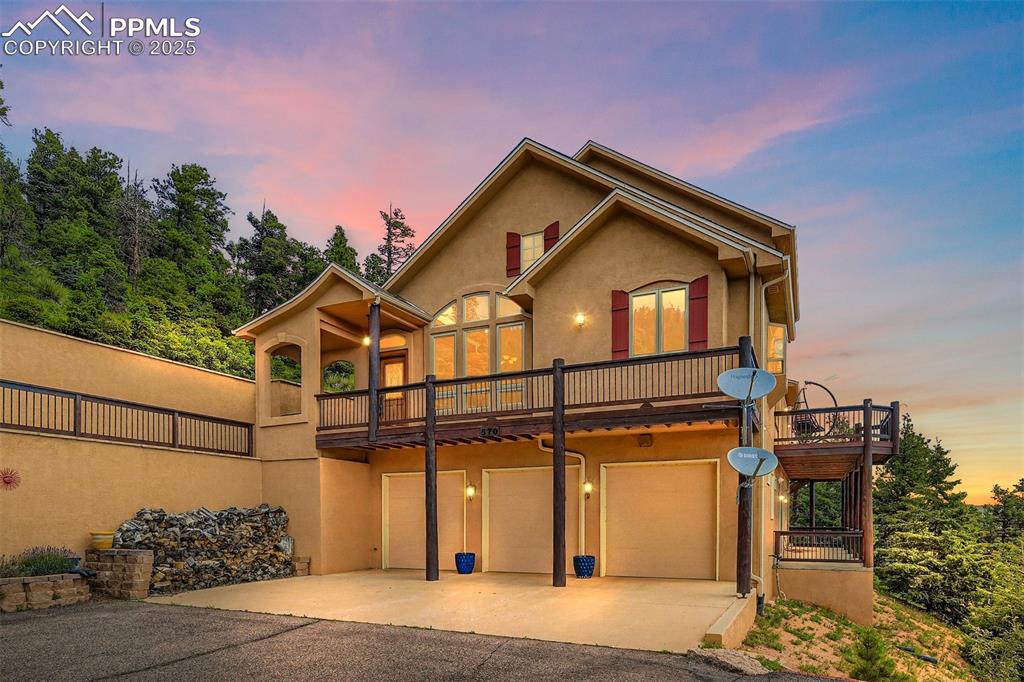 Don't miss this Top Of The World listing!  NEW ROOF AND SKYLIGHTS!  NEW EXTERIOR PAINT! Looking for views and all that classic luxury has to offer? This one has it all. Expansive mountain and city views from every bedroom and living area!  With all the charm and warmth of a true Colorado mountain home, the quality and craftsmanship of this two-story stucco gem is fully displayed.  Upon entering, notice the perfectly placed window seat and the custom wood entry door.  This entry area opens to a huge great room, complete with the elegance of a custom overlook from the second story, two-story vaulted ceiling, custom floor to ceiling windows and skylights, wood plank floor, speakers, a two-story fireplace, and an exit through French doors to the custom deck which overlooks Colorado Springs and the Plains through valley and the mountains below.  The kitchen will delight the chef with upgrades and quality appointments, including stainless steel appliances throughout: gas cooktop, wall oven and microwave, dishwasher, refrigerator, and ice machine.  Granite counters, breakfast bar, brushed bronze fixtures, including a touch-faucet, a counter bar, two kitchen sinks, a garden window, a built-in desk area and pendant lighting complete the elegant feel of the kitchen area.  The master bedroom is generous in space and luxury, featuring floor to ceiling windows and a custom door that exits to the deck.  The fireplace in the master bedroom is perfect for cozy Colorado nights.  The ensuite 5-piece master bath includes a picture window that looks out to the city of Colorado Springs and further out to the Colorado Plains.  The large walk-in master closet allows for lots of storage.  Upstairs, the two bedrooms and the loft have views unmatched. A charming bathroom is shared by these spaces, complete with a custom vanity.  The basement includes a family room area with doors that open to a covered porch.  Don't forget the massive storage room with radiant floor heat! See it today!