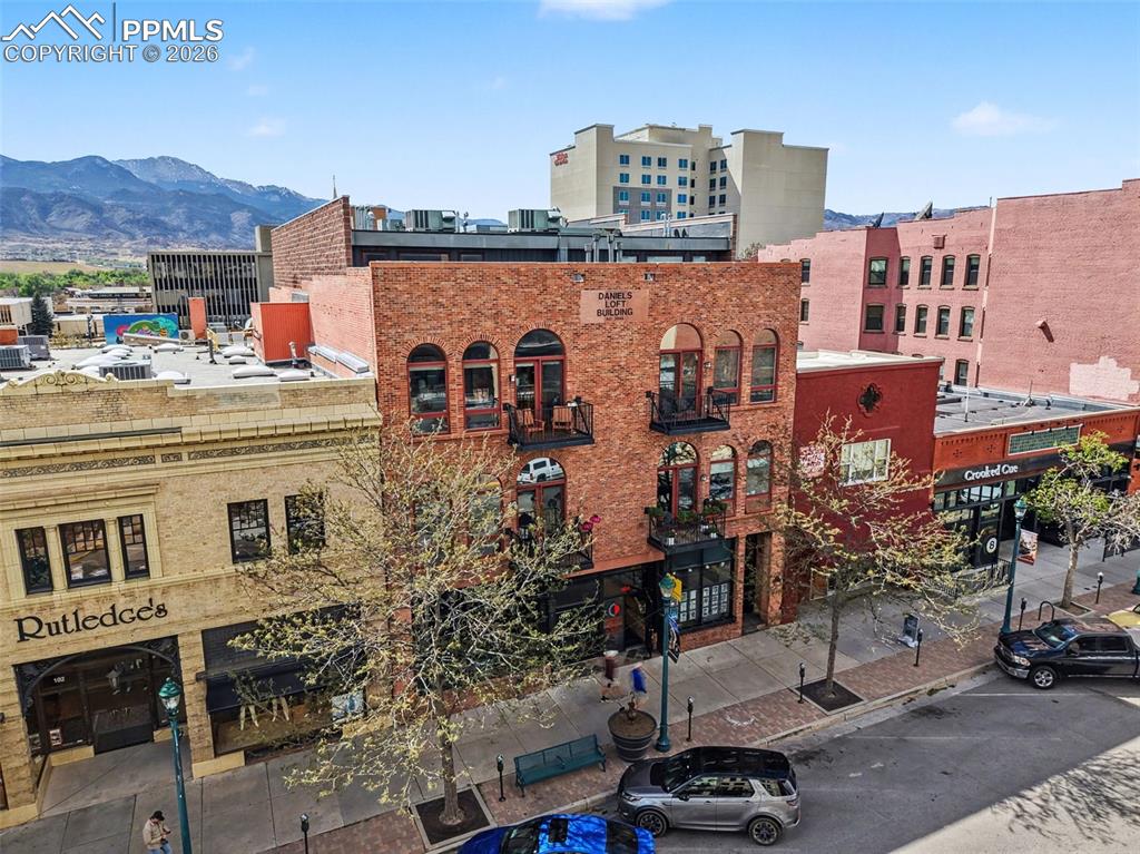 In real estate, it’s always about location, but with this beautiful light-drenched loft on one of the most prestigious blocks of the most prestigious street in downtown Colorado Springs, there's no way you can go wrong.  The Daniels Building Downtown has been part of Colorado Springs history since its building in the 1880’s and continues the tradition to this day.  Not only is the entirety of Downtown’s cultural and entertainment amenities at your door step, but the outdoor life for which Colorado Springs is known is only minutes away, with the entry to the Santa Fe Trail less than three blocks away serving as your gateway to the entire system of running, hiking and cycling trails that define the Colorado lifestyle.  Highlighted by a perfectly balanced blend of old and new, this 1,737 sq. ft. home has a flexible design that works well for entertainment as well as everyday living.  The spacious living and dining rooms that provide walkout access to a beautiful balcony are the heart of the main level and share the space beautifully with an open kitchen featuring abundant countertops and cabinetry, stainless steel appliances, and the necessary breathing room to easily share the space with your favorite sous chef. To round it all out, the additional main level bedroom with en-suite bath and beautifully exposed brick wall is currently outfitted with a Murphy Bed, but can also work well as an office, media room, or literally anything your imagination may come up with.  The entire upper level is devoted to the master bedroom suite, featuring a five piece bath, custom designer closet, and well a well tucked laundry closet.Finally, this well maintained and well appointed building features a high level of security with coded entrances into the building and the elevator, as well as a secured street level garage and a gigantic storage space (9'x11'); conveniences rarely found in downtown residences of this kind.  It truly must be seen to be appreciated.