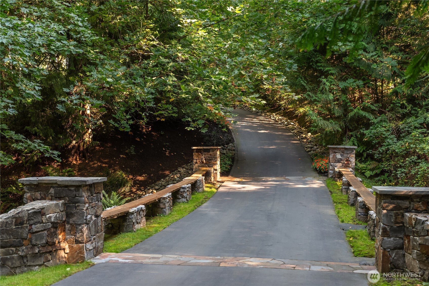 Tree-lined driveway with stone entry pillars