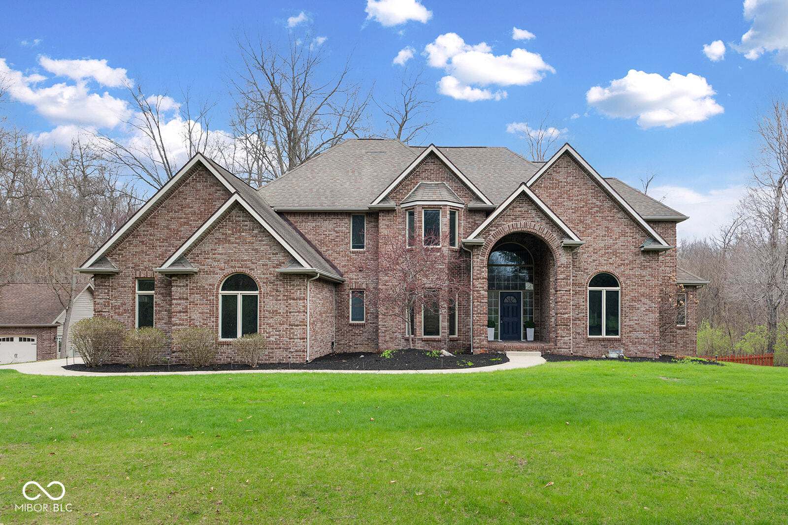 Over 10 acres with 5,000+ finished sq ft and a 6-car garage-hard to find this combination this close to town. Flexible layout supports a variety of living arrangements with a main-level primary suite, multiple living areas, and a walk-out basement with full bath, wet bar, and separate spaces for recreation, work, or extended use. Main level includes primary suite with 2-sided fireplace, den and massive great room with gas fireplace, overlooking wooded backyard. Two staircases lead upstairs to three bedrooms and two full baths. Outdoor features include sunroom, large deck, pond, fenced yard, and established fruit trees and berry bushes. Zoned HVAC, two water heaters (electric and gas), and backup generator. Private setting in Haggarty Hills minutes from I-65 and area hospitals. 1 year home warranty included.