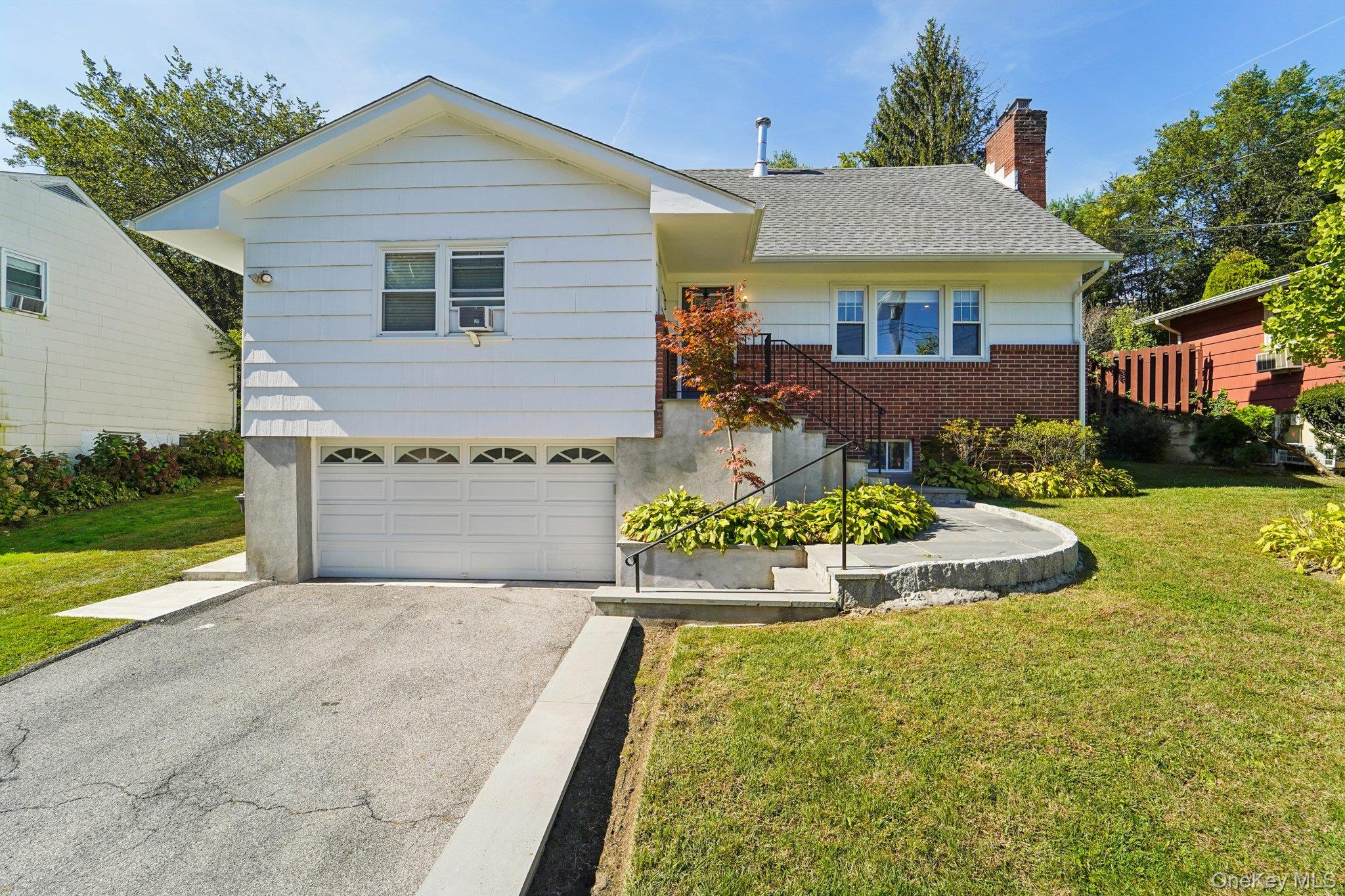 Renovate and spacious 5 bedroom 3.5 bathroom colonial ideally located offering privacy and convenience.  This home has have been freshly painted, maintained and exterior improvements just completed.  Interior is newly renovated and upgraded with hardwood flooring, open designer kitchen featuring quartz countertops, custom subway tile backsplash, stainless steel appliances, recess lighting and more.  This home is open and offers a bright and vibrant feel.  Bedrooms are oversized, full finished basement, 2 car attached garage, newer roof and mechanical.  Located close to Metro North, offering easy access to NYC,  retail shops, parks, restaurants and more.  Backyard is an amazing natural garden with three levels providing a serene relaxed feel.  This home offers it all and is sure to exceed buyers expectations.