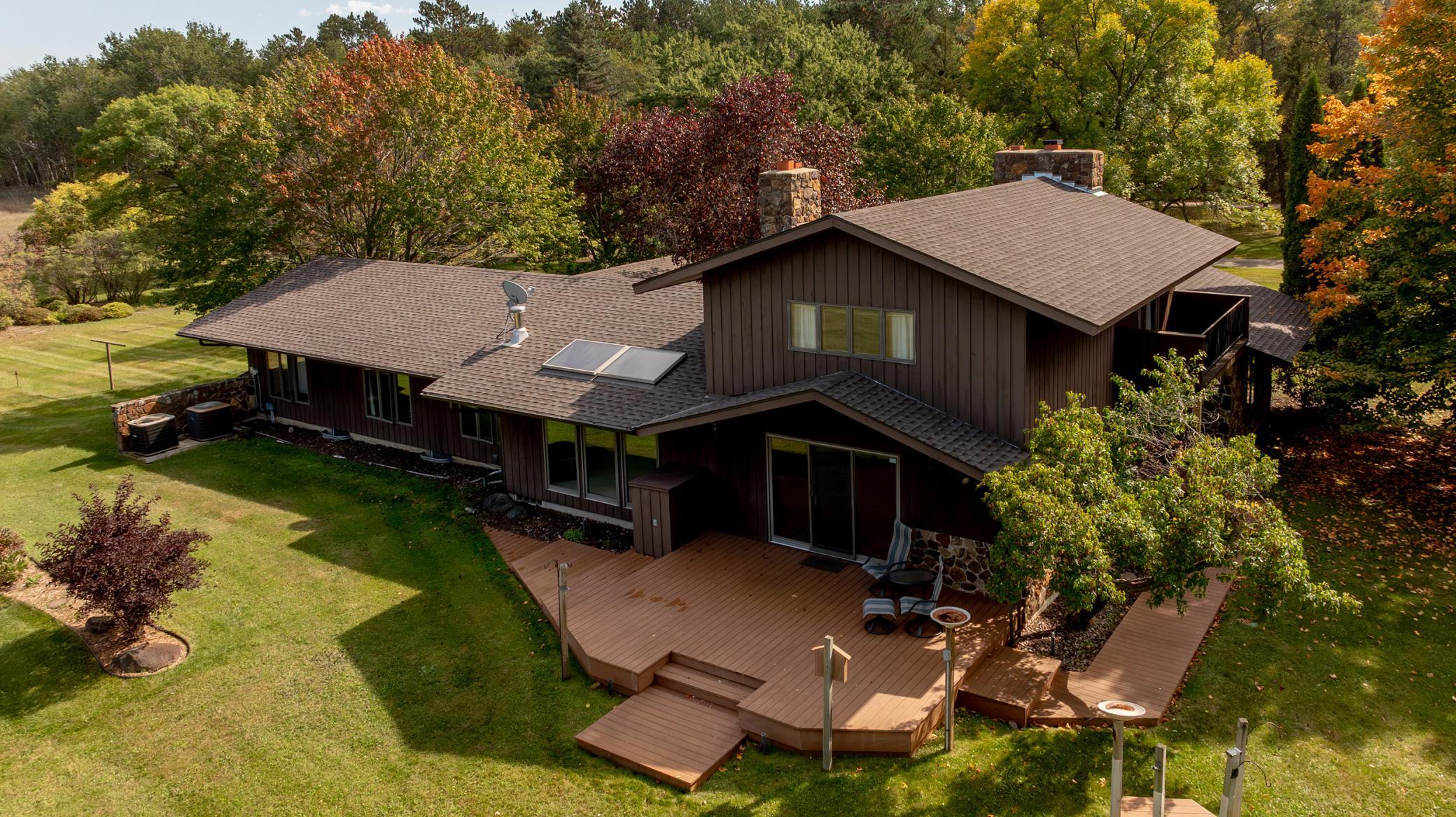 Opportunity abounds to own this picturesque family legacy property adjoining Whitetail Run Golf Course on 11.9 beautiful acres! This custom-built one-of-a-kind home features over 5,000 sq. feet of living space and has a nostalgia charm throughout!  Upon entering, you will be greeted with the oversized great room with a beautiful vaulted ceiling, 2 massive stone fireplaces on the main level, with one being a double-sided fireplace, well-appointed kitchen set up with entertaining in mind, hardwood floors, 2 laundry rooms, upper-level primary suite with a private balcony overlooking the golf course ~ this is the perfect spot to sit back and relax! Stepping into the lower level will find a large family room, rec room with a wet bar along with a bonus play nook for the kids! 2-car attached and heated garage, 36x24 detached garage for additional storage or workshop area, small stable and property is surrounded by a charming picket fence.  New roof in 2024 and a new septic has just been installed. Opportunity abounds in this beautiful legacy property on Whitetail Run Golf Course  ~ which was voted the best public course in Minnesota!