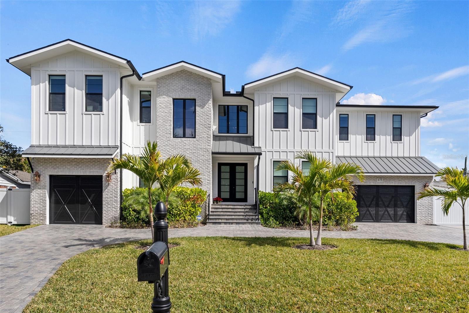 Highly sought-after Davis Islands newer construction by TB Homes offering over 5,700 square feet of air-conditioned living space with 5 bedroom suites, including a first-floor guest suite, 2 powder baths, and a rare 3-car garage configuration (2-car + separate 1-car). Thoughtfully designed for both everyday comfort and elevated entertaining, the home features a private office/study, dedicated gym, first-floor playroom or flex space, spacious media room with kitchenette, formal dining room, expansive great room, eat-in chef’s kitchen with oversized island, walk-in pantry, and a functional mudroom/drop zone.The luxurious second level includes a generous primary suite with spa-inspired bath, multiple walk-in closets with custom built-ins, loft space, and well-appointed secondary bedroom suites, creating ideal separation and flexibility for family or guests. Custom closet systems are installed throughout both the first and second floors. A shaft for a future elevator extends from base grade through both floors for long-term convenience.The fully enclosed backyard is a private resort featuring a saltwater heated pool and spa, silver travertine decking, low-maintenance turf green space, a mosquito misting system, and a covered lanai with outdoor kitchen—perfect for year-round Florida living.Built with quality and durability in mind, construction highlights include two-story concrete block construction, Hardie board concrete siding, brick accents, impact-rated windows and doors, and elevated design standards throughout. Interior finishes showcase wide-plank oak flooring, smooth drywall, detailed millwork, custom cabinetry, Sub-Zero/Wolf appliances, and designer marble and porcelain tile in all wet areas.Modern convenience and technology are fully integrated with whole-house WiFi, a comprehensive AV system with distributed speakers throughout the home, a whole house water filtration system, and a full-house generator for peace of mind and uninterrupted comfort.Located on beautiful Davis Islands, enjoy walkability and golf-cart access to village shops and dining, waterfront parks, bike paths, tennis courts, dog parks, marina, beach, and the historic public pool—just minutes to Downtown Tampa, Water Street, Sparkman Wharf, Tampa General Hospital, and the Riverwalk, with convenient access to Tampa International Airport.