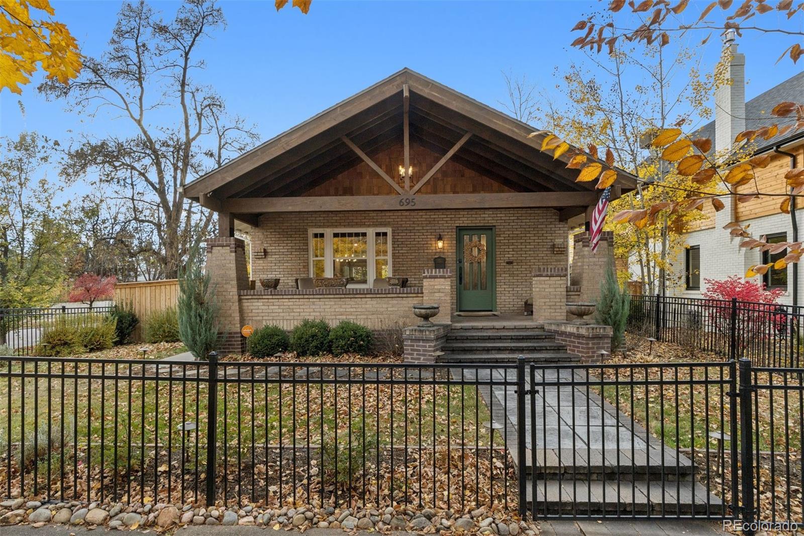 Set on a sunlit corner lot just blocks from Washington Park and the boutiques and dining of Bonnie Brae and South Gaylord, this historic East Wash Park bungalow has been fully reimagined for modern living. Thoughtful renovation throughout blends timeless architecture with a clean, contemporary aesthetic. The main level unfolds beneath vaulted ceilings accented by striking exposed beams, creating a sense of volume and warmth. An open-concept layout seamlessly connects the living, dining, and kitchen spaces; ideal for both everyday living and entertaining. The stunning kitchen is appointed with high-end appliances and a built-in banquette for casual dining. A main-level primary suite offers comfort and privacy, complemented by a walk-in laundry and mudroom designed for effortless daily living. An open staircase with a custom iron banister leads to the finished lower level, where two additional bedrooms; each with ensuite baths offer exceptional flexibility for guests or family. A media room anchors the space, with a dedicated niche ideal for a home office or fitness area. Outdoor living is equally compelling. The expansive backyard features a large patio with pergolas and a fire pit, creating a natural extension of the home for year-round entertaining. A newly constructed oversized two-car garage includes stair access to a versatile loft space above. With all-new plumbing, electrical, and mechanical systems, designer-selected finishes throughout, and an exceptional location near one of Denver’s most beloved parks, this residence delivers historic charm with the confidence of a full-scale, modern renovation.