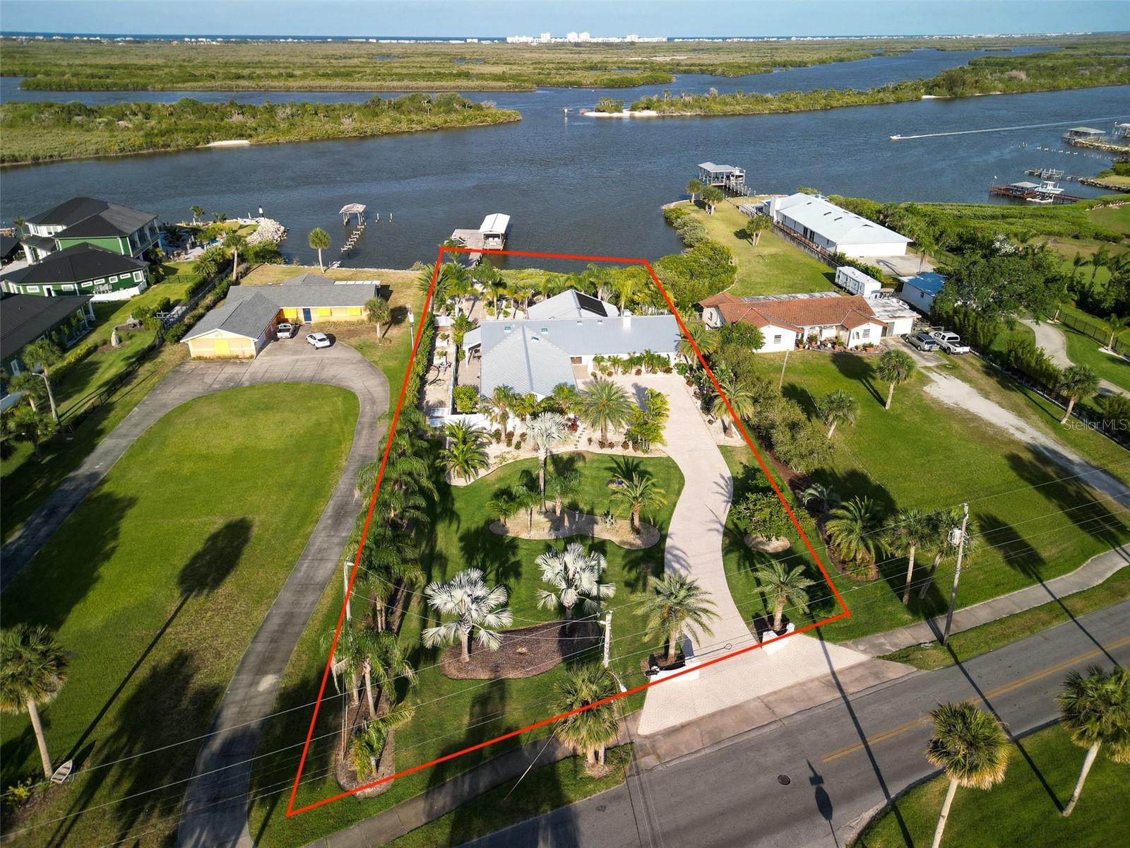 Directly on the Intracoastal, this 3 bdrm, 3 bath brick POOL home has 2754 sq ft living area and features a deepwater dock and a 1215 sq ft garage with room for 5 or more cars and toys!  Beautifully renovated kitchen and baths with quartz counters.  There are impact double paned windows throughout and bonus storm shutters too.  Tile flooring in all rooms and plantation shutters throughout. Get cozy by the wood burning fireplace in the living room, or party in the amazing 31x20 family room with windows all around framing the sunrises and abundant wildlife. Soak in river views from almost every room. Enjoy the solar heated salt pool with access from the primary suite or the family room.  Shower off on the private north side patio.  Relax in the hot tub on the south patio with access from the guest bedroom and the family room, too.   There are multiple places to dine and play both inside and out!  Don’t miss the spacious garage with 25.8 feet of depth and 4 overhead doors that are each 10 foot wide, along with an adjoining workshop and Tesla charger.  Convenient additional space between the property line and the north fence is the ideal location to store your boat trailer(s).   Well water for irrigation.  Standing seam aluminum roof 2021.  Lennox HVAC 2019.  The boat slip is appx 28x10, but the area that is now decked extends under cover for another 19 feet.  There’s additional 23x23 of dock decking as well and plenty of room to moor other watercraft. .  Please refer to the survey which reflects considerably more property than the tax assessor’s office reflects.  With 129’ on the Intracoastal this super clean well-maintained property is worth a close look!