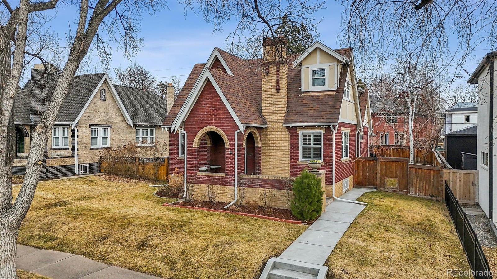 Charming brick Tudor on coveted South Race Street with a generous 6,240 sq ft lot. Ideally positioned in the heart of East Washington Park, this beautiful red brick home offers exceptional space, character, and one of Denver’s most desirable locations—just a few blocks from Washington Park and minutes to Cherry Creek North. Set on an oversized lot for the neighborhood, the expansive yard provides plenty of room for outdoor entertaining, gardening, play, or dogs to roam, and features a mature fruit-producing peach tree. The lot also offers long-term flexibility, including potential ADU options (subject to city approval). Inside, the home feels equally spacious, with soaring ceilings and ample square footage throughout. Classic architectural elements inside and out—including hardwood floors, coved ceilings, and fireplaces with original ornamental tile—add warmth and timeless character. The kitchen offers generous space with a large island footprint, granite countertops, stainless steel appliances, and abundant cabinetry for storage. Two main-level bedrooms share a charming Art Deco-inspired bath. Upstairs, the primary suite spans the entire level and includes a spacious retreat with a Juliet balcony. The en-suite five-piece bath features a soaking tub, dual sinks, and an oversized steam shower. A walk-in closet with exposed brick and natural light completes the space.The bright, warm basement with gas fireplace and new modern carpet includes a large recreation room with wet bar and refrigerator, along with a bedroom, full bath, laundry room, and storage closets—providing additional flexibility for guests, work, or recreation. A finished two-car garage with heat and cooling offers year-round comfort and versatility for vehicles, hobbies, or workspace.Centrally located near Washington Park and the shops, dining, and amenities of Cherry Creek North, this home offers walkability, lifestyle, and long-term value in one of Denver’s most sought-after neighborhoods.