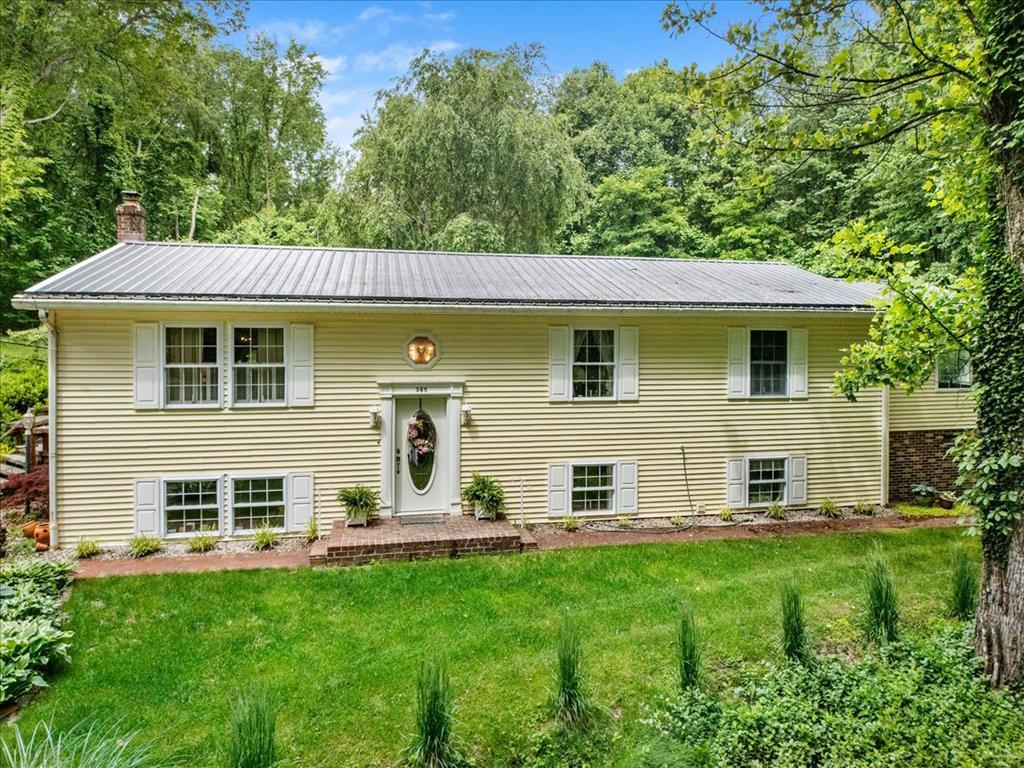 Privately situated in the scenic foothills of Southwest Virginia, this beautifully maintained split-foyer cottage offers the perfect blend of comfort, privacy, and mountain charm. Situated on a secluded wooded lot overlooking the road below, this inviting property features approximately 2,954 finished square feet with 3 spacious bedrooms and 3 full baths, all conveniently located on the main level. From the moment you arrive, you'll appreciate the home's attractive combination of brick and vinyl siding, durable metal roof, leaf-filter gutter guards, and peaceful natural setting. Inside, warm and welcoming living spaces showcase a blend of wood, tile, and carpet flooring, creating a comfortable atmosphere throughout. A whole-house water softener system and security system add convenience and peace of mind. The spacious primary suite is a true retreat, featuring a jetted soaking tub, vanity area, enormous walk-in closet, and plenty of room to unwind after a long day. The lower level offers exceptional additional living space with a large family room highlighted by a cozy wood burning fireplace, a separate sitting room with an electric fireplace, and a conveniently located laundry area. An additional unfinished basement area of approximately 173 square feet provides valuable storage space. Enjoy the beauty of every season from the charming, enclosed porch just off the dining room—the perfect place for morning coffee or evening relaxation. Outdoor living is equally impressive with a large open deck, fire pit area, and plenty of space to entertain family and friends while enjoying the surrounding mountain views and privacy. A standout feature of this property is the detached two-car garage with exterior side entry and a large unfinished space above the garage area. This versatile space offers tremendous potential for a future guest suite, Airbnb, home office, recreation room, workshop, or income-producing rental opportunity, subject to local regulations and approvals.
