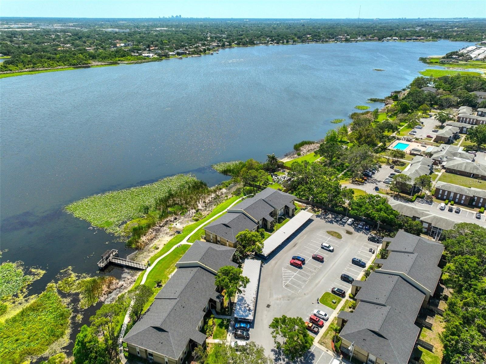 Serene gated community on Seminole Lake offers a carefree lifestyle. This perfectly remodeled 3 bedroom 2 bath condo on the 2nd (top) floor in the heart of Seminole is truly move-in ready. The open floor plan offers generous space for family gatherings and is designed for living and entertaining with a touch of sophistication with both modern and classic decor. The kitchen offers refined elegance with white quartz streaked with modern gray vein countertops and breakfast bar, deep stainless steel sink, all newer stainless steel Samsung Smart electric range with air fryer and convection oven, matching microwave, dishwasher and GE refrigerator. The spacious pantry offers additional convenient storage. The dedicated dining room provides private space for casual or special occasion meals. The spacious open plan living room is accented with crown molding, stainless steel remote fan and has a slider to the lovely screened lanai. The lanai is privately situated overlooking nature's green space and is perfect for quiet meals, reading and relaxation. All of the main living area floors have 16" easy to maintain tile. The primary bedroom also overlooks green space and has a second slider to the lanai. In addition to the walk-in closet the ensuite bathroom has a 30" vanity with studio design collection gold faucet, updated elegant stone look tiled step-in shower also with gold fixtures. The 2nd and 3rd bedrooms, in this split bedroom plan, both have built in closets and both have slight views of Lake Seminole. The 2nd bathroom, conveniently adjacent to the 2nd & 3rd bedrooms, is also updated with a luxury 37" vanity and also has studio design collection gold faucets. This bathroom is complete with a white tiled bathtub enclosure. The GE 24" steam washer and the 24" vented SensorDry dryer, both hidden behind closet doors, will be appreciated for its convenience. The community's superb amenities are equally appealing. Some of which include a clubhouse with fitness center, saltwater pool, spa, relaxing pergola with seating and grilling area, outdoor fireplace, fishing dock, kayak storage and more. This hidden gem community has quick access to some of the area's top rated beaches. Schools, restaurants, grocery stores and shopping are also conveniently located and has easy access to the area's major airports. Pets are welcome. Reserved parking. Make an appointment to view this amazing property. You will not be disappointed.