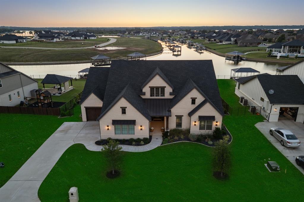 Beautifully maintained, one-owner, single-story home on the water in The Resort—the only 24-7 gated & guarded golf course community on Eagle Mountain Lake! Built in 2022, this former model home offers 4 beds, 3.5 baths, dedicated office, media room, and flex space. Hardwood floors throughout NO carpet! Open-concept design with soaring ceilings, custom beam, floor to ceiling fireplace, rich wood floors, and large windows showcasing canal views. The chef’s kitchen is a dream, with quartz countertops and backsplash, a built-in commercial-grade refrigerator, gas range, oversized walk-in pantry, extensive cabinetry, and custom touches like under and over cabinet lighting, two reverse osmosis systems, and a whole-house water softener. Enjoy entertaining with the media room and additional flex room right off the living area. Spacious primary suite overlooks the canal and features spa-like en-suite bath and separate his & hers walk-in closets. Three guest bedrooms with two full guest baths + powder bath for visitors. The designated office space overlooks the canal and has French doors. The backyard has plenty of space to build your dream outdoor oasis -  a pool, extended patio, or anything you envision! Enjoy your own private boat dock with 2 PWC slips and a lift, lakeside living has never been easier. Additional upgrades include: 41 paid-off solar panels (seller will remove if undesired), HVAC serviced biannually, soft-start units on both systems for extended life., and custom plantation shutters throughout. Community amenities include: 19 hole golf course, clubhouse with restaurant & bar, 2 pools, fitness center, playground, sports courts, private beach with pergolas, boat ramp, and more! Don't miss this rare waterfront gem in one of Eagle Mountain Lake’s most exclusive communities!