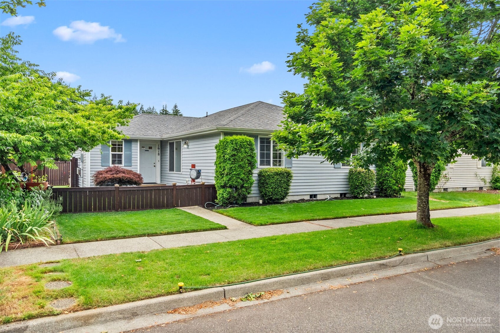 Welcome home! From the moment you walk in, it is clear this home has been truly loved and well cared for. Turn-key and move-in ready, the location delivers with easy access to shopping, dining, and schools — the icing on the cake. As summer heats up you will stay cool with forced air A/C throughout.  This charming 3 bedroom, 2 bathroom rambler offers single-level living with no stairs and a smart, functional layout. The kitchen features generous storage and flows seamlessly into the living and dining space, anchored by a cozy fireplace that serves as a natural focal point. A great room tucked just off the entrance to the right creates the perfect space for entertaining or relaxing.  The generous primary suite easily accommodates a king-size bed and includes a private en suite bathroom. Two additional bedrooms and a shared bath round out the floor plan with maximum comfort and flexibility for any lifestyle.  Commuters take note — you are just 30 minutes from the JBLM main gate!