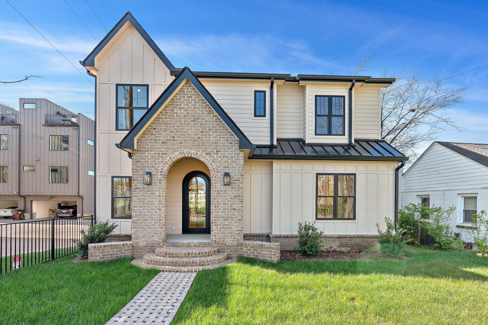 Experience elevated living in this beautifully designed modern farmhouse nestled in one of Nashville’s most sought-after neighborhoods. This thoughtfully crafted home offers high-end finishes, open-concept living, and a rare detached guest house—perfect for guests, in-laws, or rental income. Inside the main home, enjoy striking architectural details like arched doorways, designer lighting, and a chef’s kitchen with premium appliances, a large island, and generous storage. The living area flows seamlessly to a spacious deck—ideal for outdoor entertaining or relaxing mornings with coffee. The serene primary suite includes a walk-in closet with custom shelving and a luxurious bath featuring a freestanding soaking tub and dual rainfall showers. Additional bedrooms are generously sized with ample natural light. Step outside to a lush green lawn and partially fenced backyard—offering both privacy and flexibility for gardening, play, or pets. The detached guest house includes its own full kitchen, living space, bedroom, and bath, making it a turnkey opportunity for hosting or passive income.