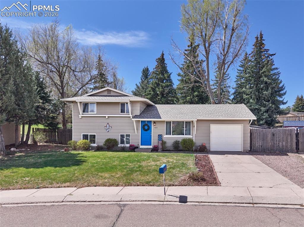 Located on a quiet cul-de-sac, this well-maintained split-level home offers a spacious lot, mature trees, and inviting indoor-outdoor living. The attractive exterior features classic curb appeal with a welcoming front entry, vibrant accent door, well-kept lawn, sprinkler system, attached garage, extended driveway, and additional gated parking with room for RV or trailer storage.Inside, the functional split-level layout offers bright, comfortable living spaces with abundant natural light throughout. The main living area features wood laminate flooring and updated lighting, while the kitchen is equipped with tile flooring, granite countertops, decorative tile backsplash, stainless steel appliances, updated fixtures, and direct access through a glass door to the covered patio—ideal for seamless indoor-outdoor entertaining. A convenient dog door provides easy backyard access for pets.The lower level offers exceptional flexibility with a garden-level family room featuring an accent wall and large windows for natural light. Currently used as a dining area, this versatile space could easily serve as an additional living room, media room, or flex space. The lower-level bedroom includes an ensuite three-quarter bath with upgraded vanity, updated toilet, and tile shower surround. A dedicated lower-level laundry area provides ample space for washer and dryer.2 Additional Bedrooms upstairs with updated bath new vanities, tile flooring, and tile surrounds in bath/shower. Additional interior upgrades include updated doors, trim, fixtures, and ceiling fan in the primary bedroom.The backyard is a standout feature, offering a generous private setting with mature trees, a spacious covered patio for outdoor dining and entertaining, fenced areas for flexibility, and room for recreation, gardening, or future customization. A storage shed adds convenient outdoor storage.This home is move-in ready and full of opportunity.