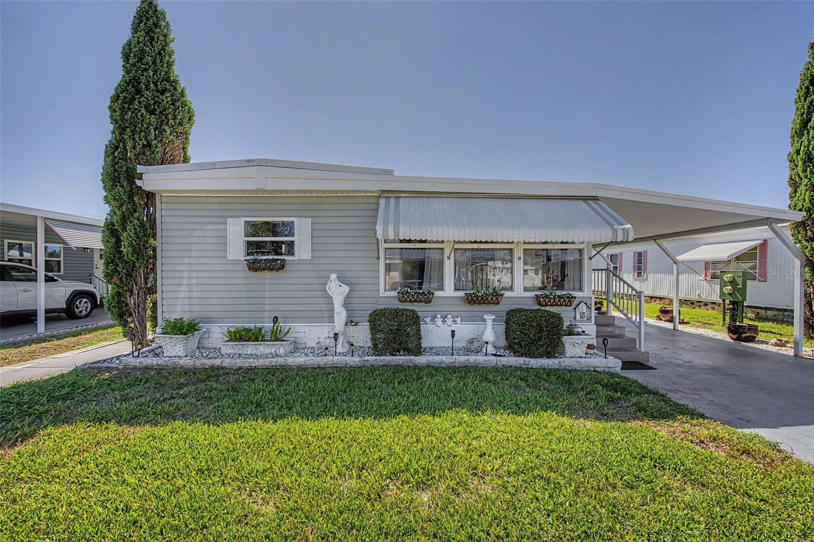 WELCOME TO TARPON SHORES, A RESIDENT-OWNED 55+ COMMUNITY WITH NO LOT RENT! This charming, FURNISHED 2-bedroom, 1.5-bath home offers something special—a GENEROUSLY SIZED, PRIVATE BACKYARD WITH NO REAR NEIGHBORS! Enjoy the peaceful outdoor setting from your COVERED BACK PATIO, conveniently accessed through the spacious rear Florida Room. It's the perfect setting for relaxing, entertaining friends, or simply enjoying your own private outdoor retreat! A second Florida Room at the front of the home provides even more flexible living space. Inside, you'll find a bright, open living and dining area with attractive laminate flooring and a WORKING ELECTRIC FIREPLACE IN THE DINING ROOM, adding warmth and inviting ambiance. The spacious kitchen features freshly painted cabinetry, updated hardware, abundant storage, and a convenient workspace. The primary bedroom offers an en-suite half bath, a wall of built-in closets and drawers, new blinds, and a laundry closet with a full-size washer and dryer. The guest bedroom features additional built-in storage and a clever office nook created from a converted closet. The full guest bathroom includes a step-in shower with grab bars. Additional highlights include a 2019 HVAC system, METAL ROOF, vinyl siding, ceiling fans throughout, easy-care laminate and tile flooring, and a spacious, widened covered carport. SOLD FULLY FURNISHED, WITH ALL FURNISHINGS INCLUDED, making your transition to Florida living that much easier!Tarpon Shores offers a large heated pool, clubhouse, pickleball, bocce ball, shuffleboard, billiards, BBQ area, library, and organized activities. The LOW $326 MONTHLY FEE includes lawn care, lawn spraying, water, sewer, trash, expanded cable TV, and internet. Located in FLOOD ZONE X, this property is conveniently situated near the Tarpon Springs Sponge Docks, beaches, parks, boating, fishing, golf, shopping, and dining. Whether you're looking for a full-time Florida residence or an affordable seasonal getaway, this is a fantastic opportunity to enjoy the Tarpon Springs lifestyle in a resident-owned community with NO LOT RENT and the $40,000 CO-OP SHARE ALREADY INCLUDED IN THE PRICE! Schedule your private showing today!