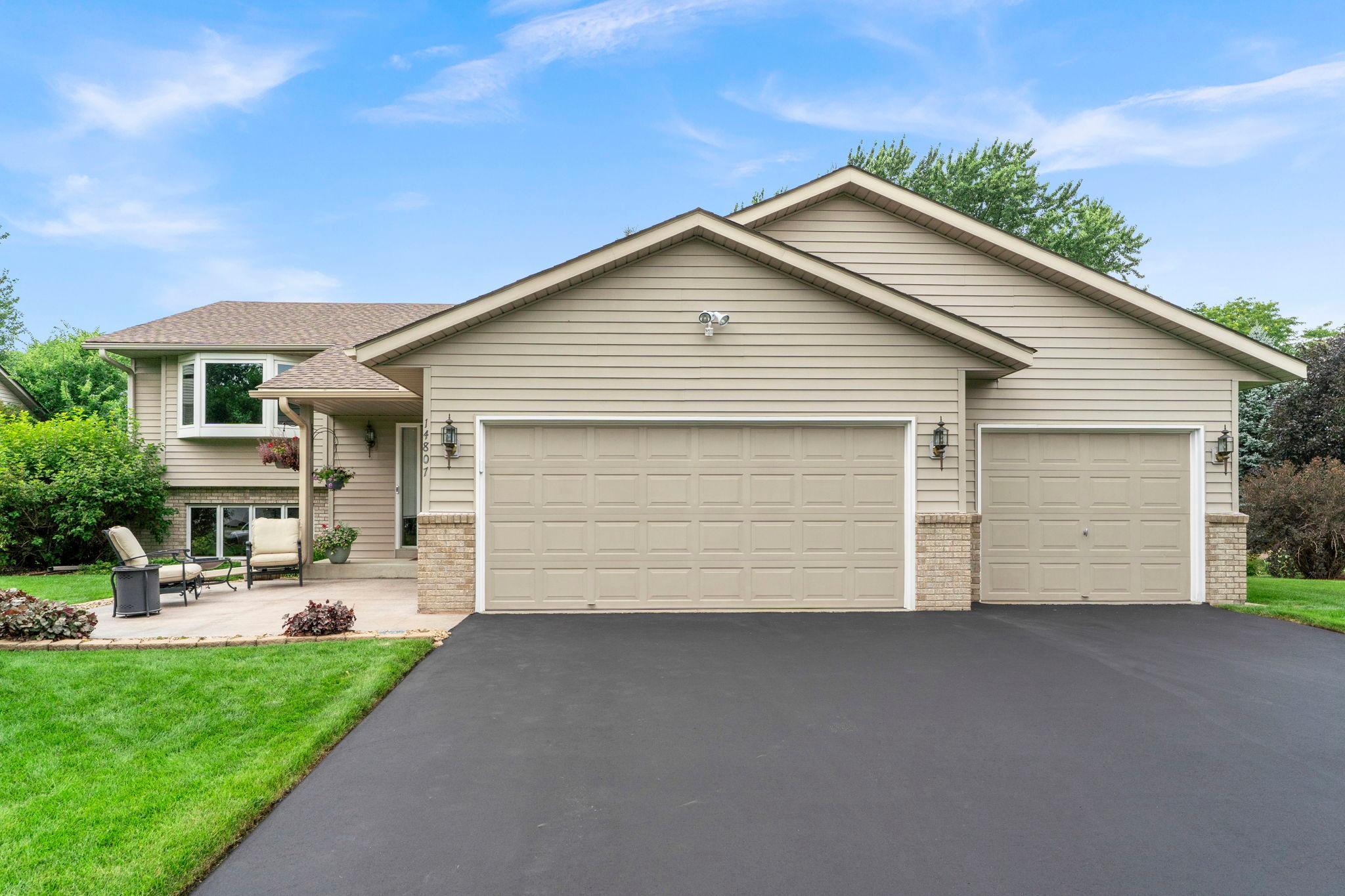 Welcome to this well maintained three level split home in Rosemount, offering three bedrooms and two bathrooms in an established neighborhood within walking distance to parks, trails, and green spaces, with nearby shopping and dining and a highly rated school district. A stamped concrete patio added in 2010 and mature landscaping welcome you to the front of the home, and a spacious foyer offers open sightlines to both levels, with wood floors, a coat closet, and access to the attached, finished three car garage.The upper level hosts a spacious living room with a 2020 bay window, hardwood floors, and 11 foot vaulted ceilings. The dining room is open to the kitchen and living room and leads to the four season sunroom. The kitchen features a tile backsplash, granite countertops, a 2022 gas and electric combo stove, a 2025 microwave, and a peninsula with additional counter space and casual dining overlooking the backyard. The sunroom, built in 1996, offers cedar paneled walls, a 12 foot vaulted ceiling, trapezoid windows, and plenty of natural light, with access to the deck, which includes a retractable awning and maintenance free decking updated in 2023. The primary bedroom includes a spacious closet and walk through access to the main bathroom, while the secondary bedroom overlooks the side yard with its own spacious closet, and both bedrooms have 2026 updated windows.The lower level, finished in 2003, includes a family room with a gas fireplace, wood mantle, and wood accented half walls, along with a wooden bar with a sink and a flex space suited for a game room, both with patio access. A concrete patio off the basement features a 50 amp outlet previously used for a hot tub. The lower level also offers a three quarter bathroom, a third bedroom with lookout windows overlooking the side yard, and a utility and laundry room with hanging storage, a utility sink, and ample cabinetry and counter space.This home offers thoughtful updates throughout, including a newer roof (2021), underground sprinkler system, updated furnace and water heater (2025), and a freshly seal coated driveway (2026), making it move in ready in a sought after Rosemount location.