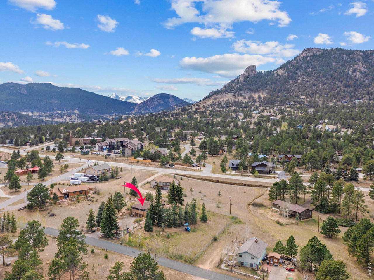 Beautifully updated ranch-style home in Estes Park, Colorado, offering the perfect blend of comfort, flexibility, and location. This four-bedroom, three-bathroom property features a bright, open main-level floor plan with hickory flooring throughout. The spacious kitchen is a standout with granite countertops, stainless steel appliances, and easy access to the backyard patio-ideal for entertaining or everyday living. A separate dining room opens to a private deck with mountain views, while the inviting living room is filled with natural light and has a cozy fireplace. The primary suite provides a peaceful retreat with a beautifully remodeled 3/4 bathroom featuring a walk-in shower, granite, and tile finishes. A second bedroom on the main level adds charm with custom built-ins, patio access, and a full bath conveniently located just across the hall. The daylight lower level offers exceptional versatility, set up as a separate living space complete with its own full kitchen with all new appliances, spacious living and dining area with fireplace, two bedrooms, a full bath, laundry, all new flooring and a private entrance through the attached two-car garage-perfect for rental income, guests, or multi-generational living. Situated on a fenced 0.91-acre lot with mountain views, the property includes plenty of outdoor space to enjoy. Located just minutes from downtown Estes Park and local schools, with miles of walking and biking paths right outside your back door. No HOA adds to the appeal of this move-in-ready mountain home. Too many updates to mention-see documents tab for a full list of upgrades!