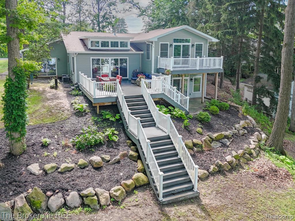 Welcome to lake living at its finest! This stunning 5-bedroom, 3.5-bathroom quad-level home is perfectly positioned on the peaceful shores of private Lake Shinanguag. Tucked away in a secluded cove and located within the award-winning Goodrich School District, this beautifully remodeled home offers the perfect blend of luxury, privacy, and recreation. Step inside to find an expansive granite kitchen that flows seamlessly into a massive living room with gas fireplace and breathtaking views of the lake. The spacious layout includes a first-floor laundry room, and a large walkout basement with ample storage space and easy access to the water. Perfect for lakeside entertaining. The primary suite has access to its own private composite patio, large walk-in closet, and a massive spa-like bathroom. Enjoy morning coffee or evening sunsets from your oversized composite deck that spans the back of the home and overlooks the wooded, beautifully landscaped yard filled with mature trees. This home was designed for enjoyment of all seasons. Summer boating, relaxing on the water, ice fishing or skating right outside your back door. With five spacious bedrooms, a versatile lower-level ideal for game nights & gatherings, a three-car garage for all your toys, this home truly has it all. This is lake life with seclusion and space, don’t miss this opportunity to own a piece of paradise on Lake Shinanguag!