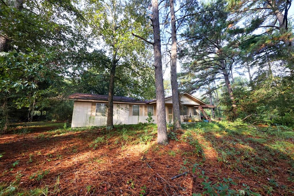 *Country Charm Meets Endless Possibility*  Nestled on a serene 7.46-acre canvas of mature hardwoods and established pines, this classic country homestead offers a rare opportunity to create your dream retreat. Just minutes from town yet worlds away in peacefulness, the property boasts a tranquil setting perfect for those seeking privacy, nature, and room to roam.  The home itself is a vintage gem waiting to be polished. With timeless front and back porches ideal for morning coffee or evening sunsets, it exudes character and charm. While it does require significant updates and repairs, its solid bones and rustic appeal provide the perfect foundation for a thoughtful renovation.  Whether you're envisioning a cozy farmhouse, a weekend getaway, or a full-scale transformation, this property invites you to bring your vision to life.  The land offers ample space for gardens, trails, or even a future guest cottage—let your imagination run wild.  If you're ready to roll up your sleeves and embrace the beauty of country living with the promise of potential, this is the place to start.