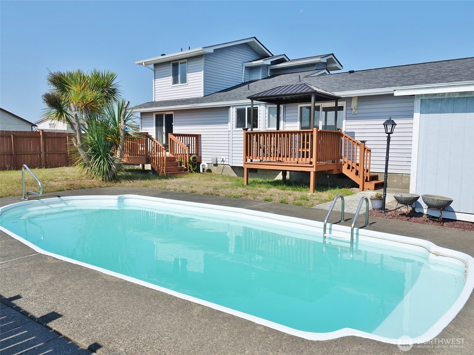 REMODELED HOME with a rare on-site Pool located near the Beach! Beachy theme and colors brighten this comfortable and remodeled home, which features 3 BD, 2.5 BA, 1481 sq.ft. and a 2-car Garage (with built-in shelves).  Ability to have 1-story living with the Living Room, Dining Room with a slider to the 2nd Rear Deck, Kitchen, Master Bedroom with an attached 1/2-Bath and a Private Deck in the Backyard, Guest Bedroom, and a Full Bath.  Upstairs features the 2nd Master Bedroom with Private Front Deck, laminate flooring, and an attached 3/4-Bathroom. Remodeled home over the last few years with new LVP, laminate, tile and carpet flooring. The Kitchen was completely remodeled about 3 years ago with quartz counters, all new cabinets with self-closing drawers, LVP flooring, Stainless-Steel Appliances, Propane Range, Eating Bar, Pantry Closet with a built-in counter and cabinets, and a Bay Window looking out over the Backyard. The downstairs Full-Bath was remodeled about 2 years ago with a new vanity, tile floors and tile surrounding the shower. Enjoy the outdoors lounging behind the Fenced Backyard with an in-ground Pool, lawn, and Shed. Brand New Roof installed in May 2026. Rear Deck off the Dining Room was replaced in June 2026. Alarm System.