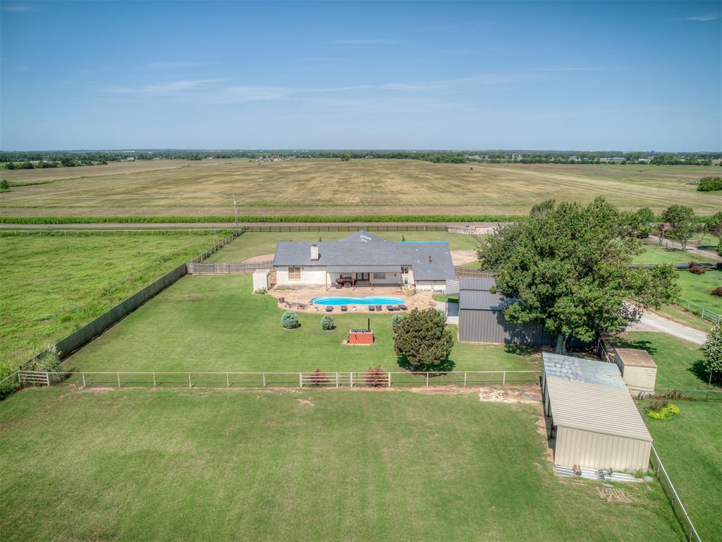Properties with this level of character, amenities, and location rarely become available in Norman! West Norman home on 2.2 acres! This unique 3 bedroom + loft, 2.5 bath home offers soaring wood-planked ceilings with exposed beams, and a stunning floor-to-ceiling stone wood-burning fireplace. The open-concept layout features a spacious kitchen with granite countertops, abundant cabinetry, stainless steel appliances, double ovens, and a large center island. Outside, enjoy your own private retreat with an inground pool, custom fire pit, insulated shop, horse stall barn, above-ground storm shelter, and wide-open space for hobbies, animals, and recreation. Additional upgrades include a premium Class 4 impact-resistant DaVinci roof installed two years ago and a whole-house water filtration and conditioning system. Acreage properties with this combination of location, amenities, and character are hard to find!