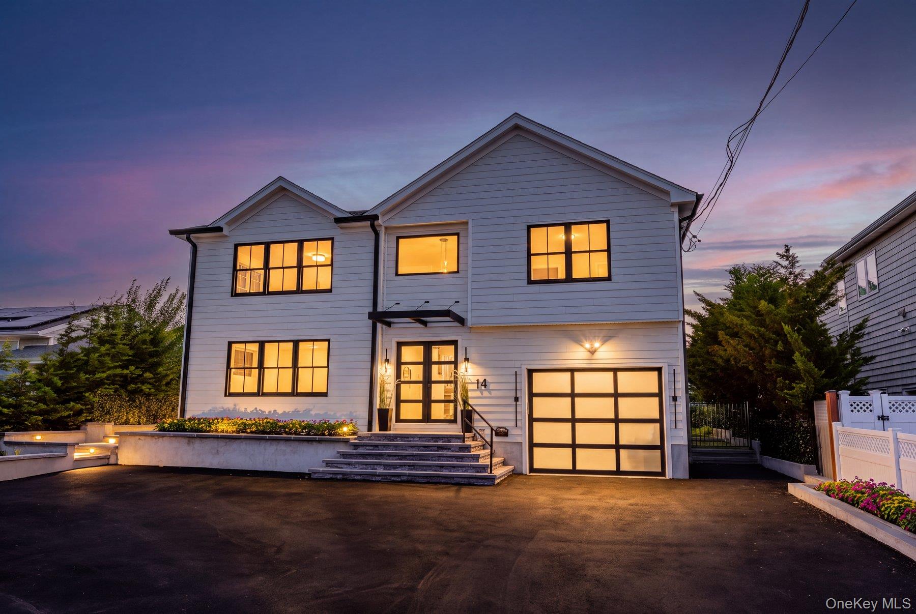 Welcome to 14 Jomarr Court, an extraordinary modern waterfront retreat offering its own private sandy beach, 60-foot pier with two floating Jet Ski docks, and spectacular resort-style backyard. Featuring 4 generously sized bedrooms, 4 full baths and a spacious loft, this exceptional residence combines sophisticated contemporary design, smart-home technology and an incredible waterfront lifestyle.Step inside to a dramatic, light-filled open-concept floor plan where clean architectural lines, oversized windows and doors, designer lighting and a striking floating staircase with glass railings create an impressive modern aesthetic. The expansive living, dining and kitchen areas flow seamlessly together, designed for both everyday living and effortless entertaining.At the heart of the home is a stunning designer kitchen featuring quartz countertops, an oversized waterfall island, custom cabinetry and top-of-the-line Thermador appliances. Oversized windows and glass doors capture beautiful water views while creating a seamless connection between the interior and outdoor living spaces.Upstairs, the spacious open loft with glass railings overlooks the main level and adds another dramatic architectural element. All four bedrooms are generously proportioned, while the luxurious primary suite is a true waterfront sanctuary. Vaulted ceilings and oversized glass doors open directly onto an incredible wraparound balcony overlooking the water, private beach, pool and grounds.The spa-inspired primary bath is beautifully appointed with floor-to-ceiling stone, double vanity, oversized glass-enclosed shower with multiple shower fixtures, designer finishes, smart toilet and radiant heat.Technology and comfort have been thoughtfully integrated throughout the home with a Savant smart-home system, Lutron lighting, surround sound throughout the interior and exterior, and radiant heat throughout the entire first floor and primary bath.Step outside and the property transforms into your own private waterfront resort. The spectacular 14’ x 28’ saltwater infinity-edge pool, approximately 5 feet deep, is surrounded by expansive lounging and entertaining areas, a fire pit and a covered outdoor living space. Beyond the pool, your private sandy beach leads directly to the waterfront and 60-foot pier with two floating Jet Ski docks, creating an exceptional setting for boating, water sports, entertaining or simply relaxing by the water.Additional features include two sump pumps, a French drain system and the added benefit of being outside the designated flood zone.From its private beach, infinity-edge pool and boating amenities to its sophisticated interiors, smart-home technology and exceptional indoor-outdoor flow, 14 Jomarr Court delivers the ultimate Long Island waterfront lifestyle — a home designed to feel like a private resort every day.