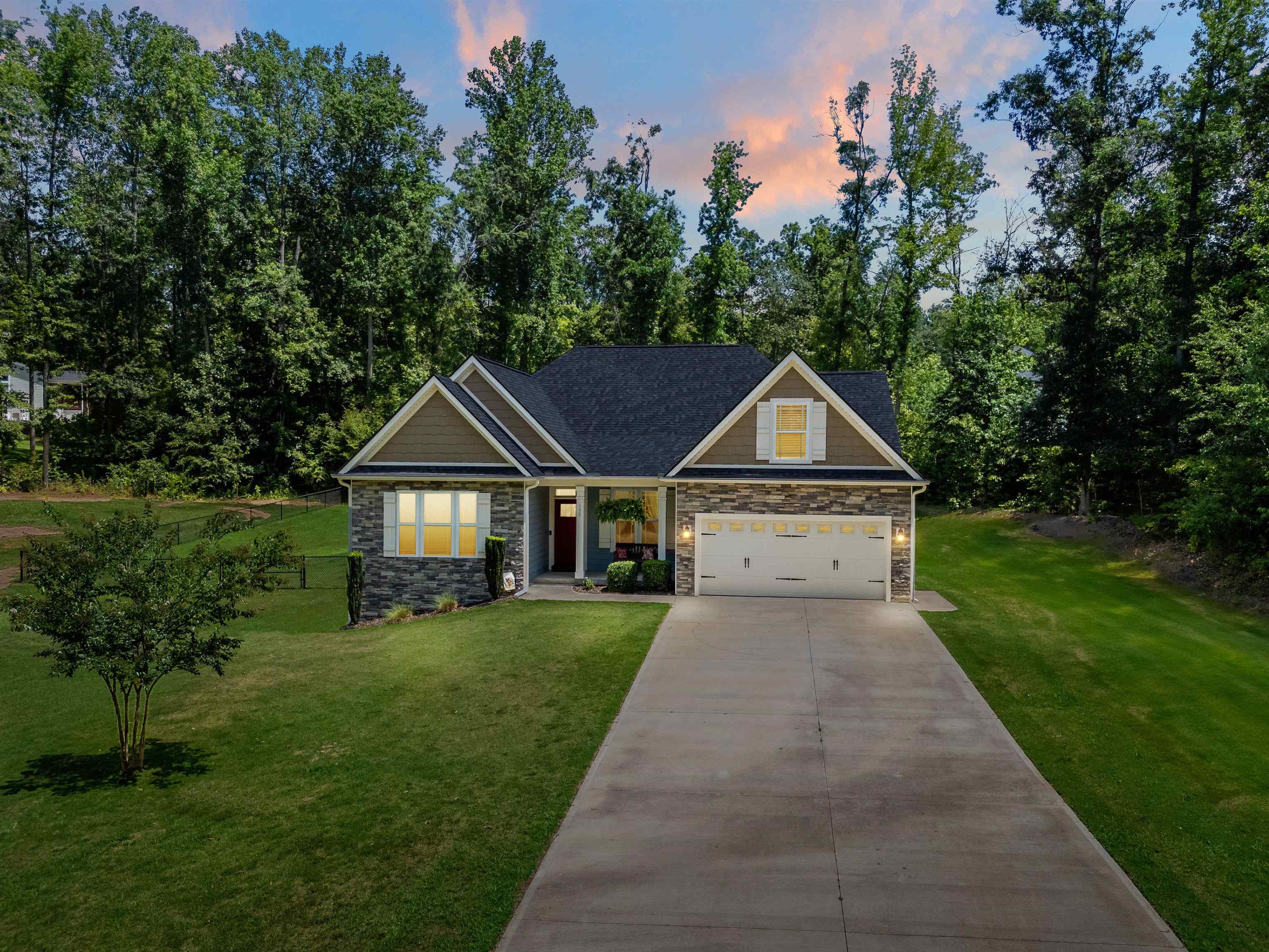Welcome to 130 Cane Creek Way—an exceptional 4-bedroom, 3-bathroom home built in 2020, offering 2,820 sq ft of thoughtfully designed living space on over an acre in the sought-after Cane Creek neighborhood. This beautifully maintained home combines custom finishes, flexible spaces, and inviting indoor-outdoor living, all just steps from Landrum High School.  Step onto the welcoming front porch and into the foyer, which opens to a private home office with French doors—ideal for working from home or quiet study. To the left, two guest bedrooms share a full bathroom, offering a comfortable retreat for family or visitors.  The heart of the home is the open-concept kitchen, living, and dining area. The kitchen features a walk-in pantry, stylish cabinetry, and a large island with seating for 3–4 barstools—perfect for casual meals or gathering with guests in the breakfast area. The adjoining dining room has a tray ceiling and opens to the spacious living room, where you’ll find arched entryways, crown molding with chair railing, rope lighting, and a cozy stone propane fireplace.  The main-level primary suite offers a peaceful retreat with a tray ceiling, accent lighting, and an ensuite bath featuring a double vanity and a spacious tiled shower. A walk-in laundry room with a utility sink adds everyday convenience.  Upstairs, you'll find a private bedroom, full bathroom, loft area, and a versatile flex space—ideal for a playroom, craft room, or additional bedroom.  Enjoy outdoor living from the screened porch overlooking the fully fenced backyard shaded by mature trees boarding the property. Grilling on the back patio lets you stay connected to all the fun—indoors and out.  This home is set on a level lot with Hardie-board siding and stone accents for lasting curb appeal. The Cane Creek community offers scenic walking trails, a covered recreation area, a playground, and a peaceful pond with a dock.  Don't miss this rare opportunity to own a well-appointed home in one of Landrum's most desirable neighborhoods.