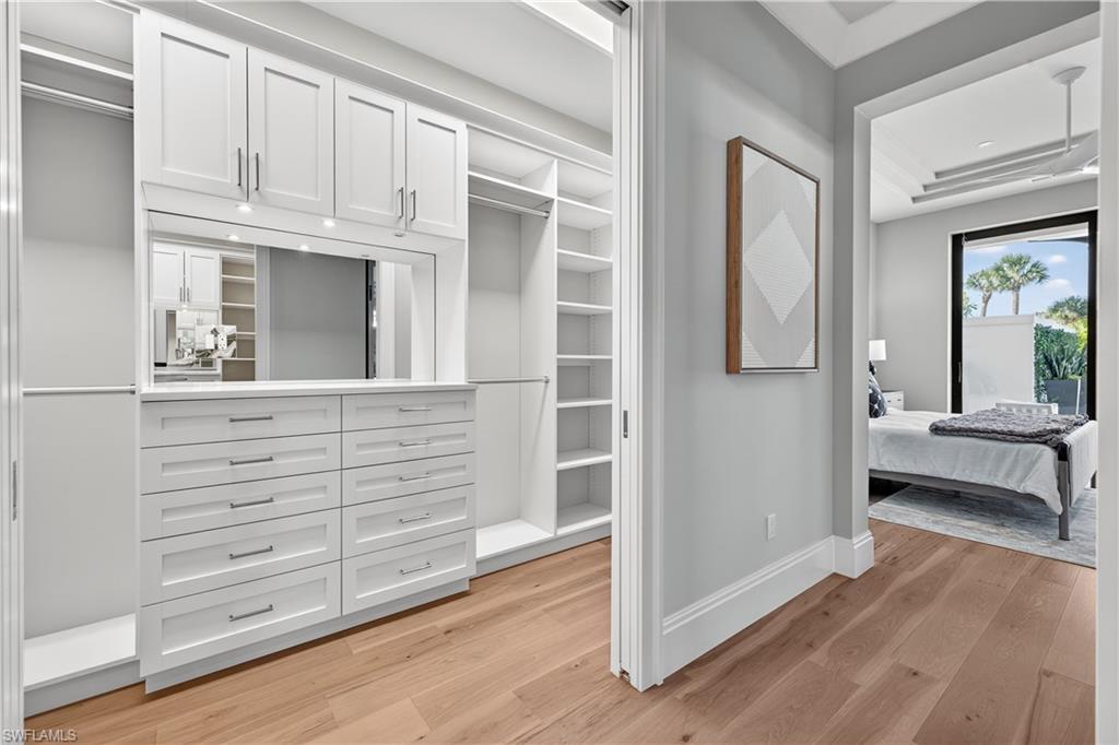 Walk in closet with light wood-type flooring