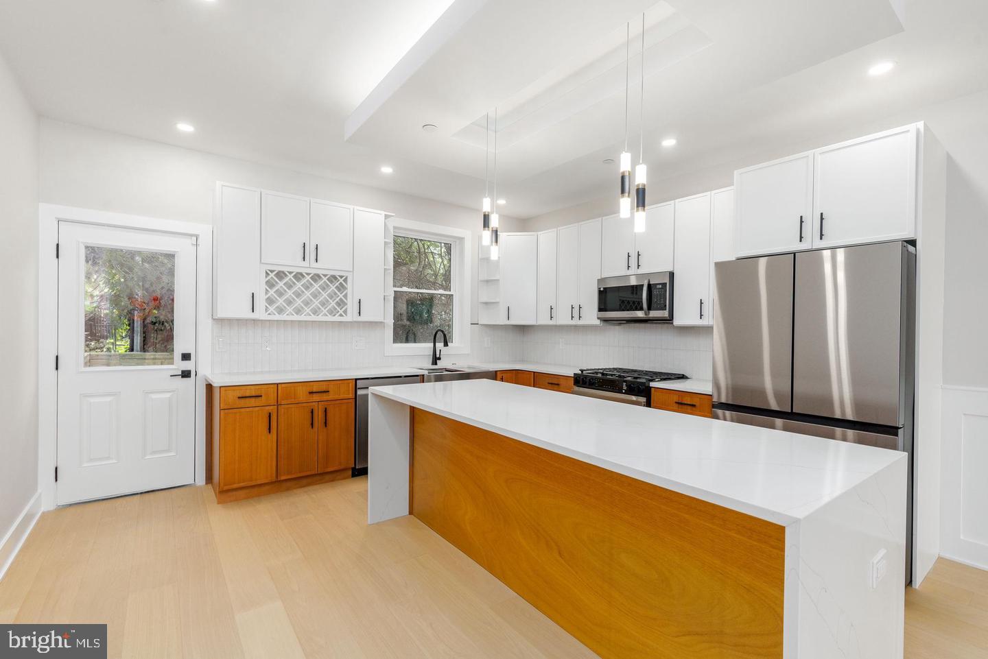 Welcome to this exceptional contemporary townhome in the heart of Point Breeze, where luxury finishes, thoughtful design, and functional living come together across every level. Enjoy a 10 year tax abatement and 1 year builder's warranty for piece of mind. This stunning 5-bedroom, 3-bath residence offers an open-concept layout enhanced by wide-plank hardwood flooring, recessed lighting, built-in Bluetooth speakers, an alarm system, and a striking custom media wall featuring a sleek electric fireplace with integrated LED lighting and designer wood-slat accents. At the center of the home, the chef-inspired kitchen impresses with a dramatic quartz waterfall island, two-tone custom cabinetry, an integrated wine rack, stainless steel appliances, a gas range, and abundant prep and storage space. The fully finished basement adds incredible versatility with two bedrooms, a full bathroom, and flexible space ideal for guests, a home office, fitness room, or media lounge. The second floor features two spacious bedrooms with custom closet systems, a beautifully appointed full bath, and a conveniently located laundry area. Privately occupying the upper level, the primary suite serves as a true retreat with a tray ceiling featuring ambient LED lighting, custom built-ins, his and her closet systems, an adjacent wet bar/coffee station, and a spa-inspired ensuite bath complete with a freestanding soaking tub, dual vanity, and oversized walk-in shower with rainfall fixture.Outdoor living is equally impressive with a fully fenced rear patio and an expansive private rooftop deck offering breathtaking views of the Center City skyline—perfect for entertaining or unwinding above the city. Additional highlights include a tax abatement, builder's warranty, and potential eligibility for Bank of America homebuyer grant programs for qualified buyers. Ideally located just minutes from Center City, this home provides convenient access to I-76, I-95, Broad Street, SEPTA bus routes, and the Broad Street Line, making commuting throughout Philadelphia and beyond effortless. Enjoy being moments from neighborhood favorites including American Sardine Bar, On Point Bistro, and the renowned restaurants, cafés, boutiques, and nightlife along East Passyunk Avenue. Outdoor recreation awaits at Chew Playground, Wharton Square Park, and the nearby Schuylkill River Trail, completing the perfect blend of luxury, convenience, and vibrant city living.