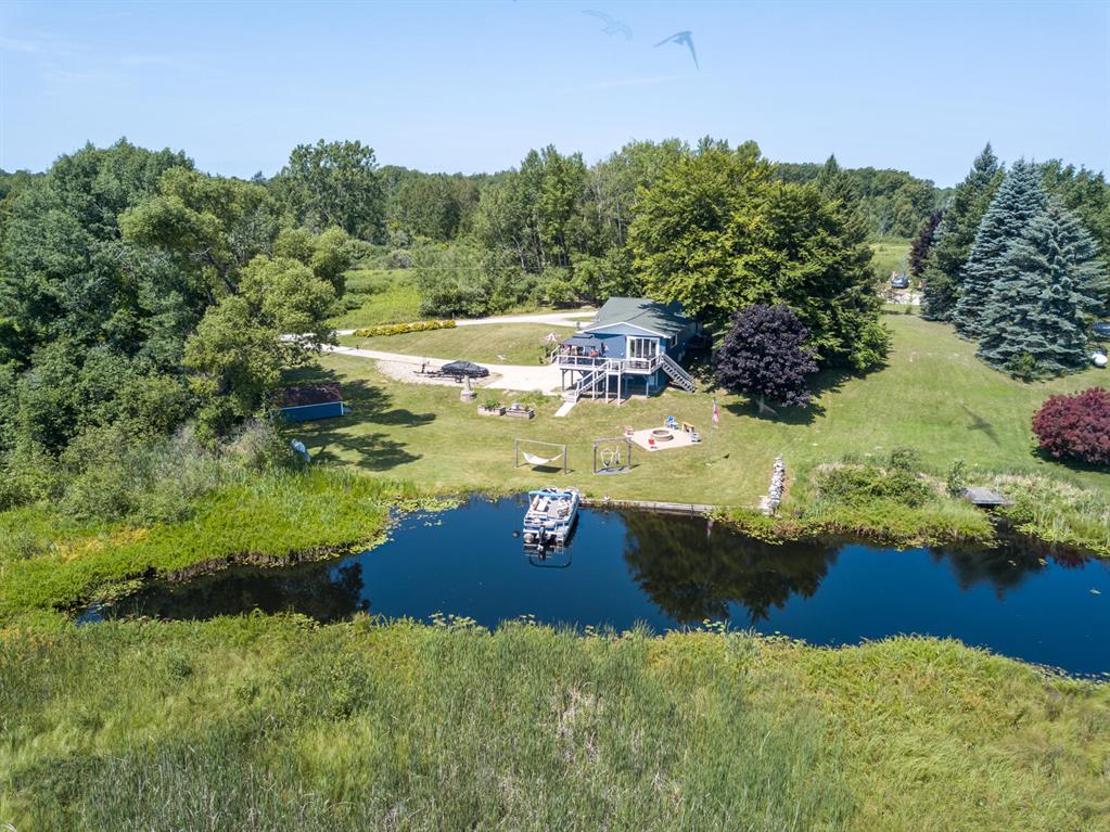 Waterfront home on All Sports Stylus Lake! This 1545 sqft, 3 bedroom home has been recently remodeled (2024) with updates including flooring, paint, windows, siding, doors, and an additional half bath on the main floor. Enjoy the spacious great room with an electric fireplace, built-in big screen, vinyl planking floors, and a door wall leading to a large composite wrap-around elevated deck offering views of Stylus Lake and the wetlands across the canal. The kitchen boasts Quartz countertops, a large center island, pot filler, and stainless-steel appliances including a gas range, built-in dishwasher, exhaust hood fan, and double door refrigerator. The primary bedroom features a fully updated bath and walk-in closet. The primary bath includes a low entry ceramic tile shower with rain-styleshower head and hand wand, along with a soak tub and custom-made Maple cabinetry. The lower level features a half bath, a bonus room with 2 closets, and ample storage space with garage access. Outside, enjoy privacy with no neighbors on one side and a vacant lot on the other. Plenty of room for RV parking, a brick paved fire pit area with water views, and access to fishing for Perch, Pike, LargeMouth Bass, and BlueGill. Wildlife abounds with birds, deer, and more. Just a short drive from West Branch and Hale. Schedule your showing today! BTVIA