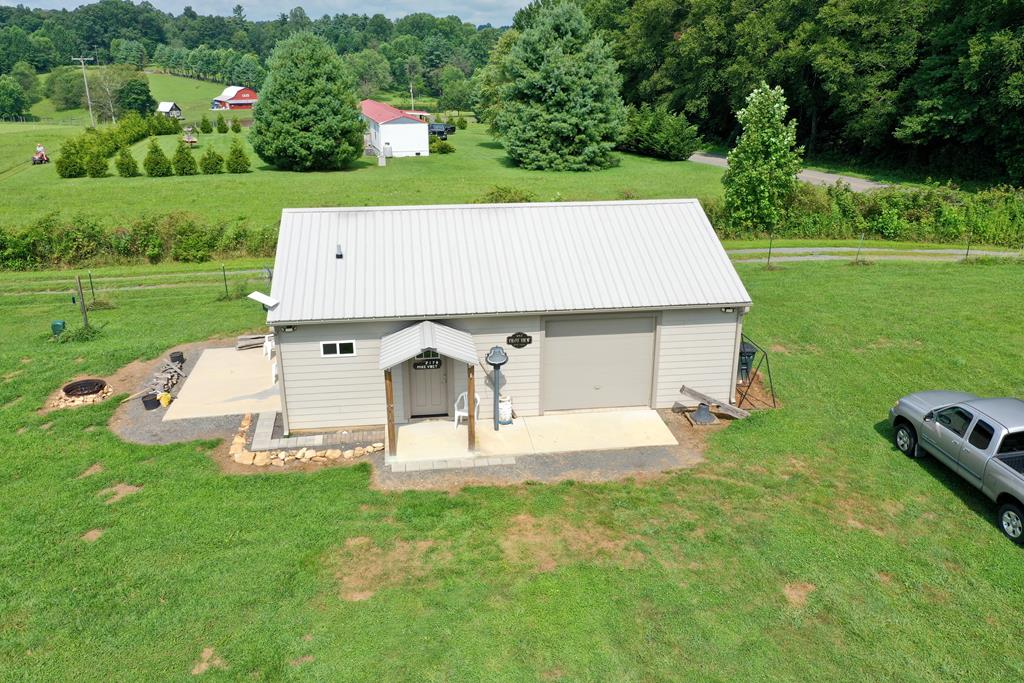 Gorgeous Pilot Mountain View!  This large lot and a cozy home with a tremendous view of the Piedmont region of North Carolina including Pilot Mountain.  No HOA and very few restrictions!  This home is so versatile with potential uses.  It is a cozy mountain getaway home with one spacious room housing the sleeping area, living space plus kitchen and dining spaces.  Come enjoy the quiet beauty of living along the Blue Ridge Parkway which is approximately 100 feet from the property.  This provides easy access for bike rides or strolls along the Parkway.  The approximately 4.37 acres also bring hiking opportunities, as well as room for your outdoor recreation, gardens or additional buildings.  You could also use this property as a cute short-term rental with its proximity to the Parkway, Fancy Gap, Mount Airy, Hillsville, Meadows of Dan and Floyd.  The garage is fully insulated and could be remodeled into extra living area without a tremendous amount of effort.   The living area has one huge window and sliding patio doors facing the gorgeous view.  The cathedral ceiling gives the living space an open, spacious feeling.  There is additional storage above the built-in closet and desk area.  The kitchen has base cabinets and shelves on one wall.  The refrigerator, stove and microwave convey with the home.  Most furnishings will be conveyed also.  The bathroom features a full-size walk-in shower with tile walls, a small window, shelves and storage under the sink. All floors in the living area are luxury vinyl plank which is easily maintained. Enjoy endless hot water with the tankless water heater.  There is an entrance foyer which opens onto a concrete porch which is partially covered.  Outside the main living area, there is a 10x16 concrete patio with a small fire pit area just off the patio. The spacious garage is fully insulated and is currently being used as a workshop and laundry area.  There are lots of nice windows to bring in the sunshine.